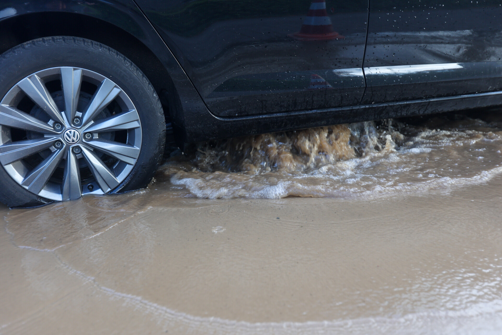Wijk zonder water door gesprongen waterleiding, auto staat vast op sinkhole