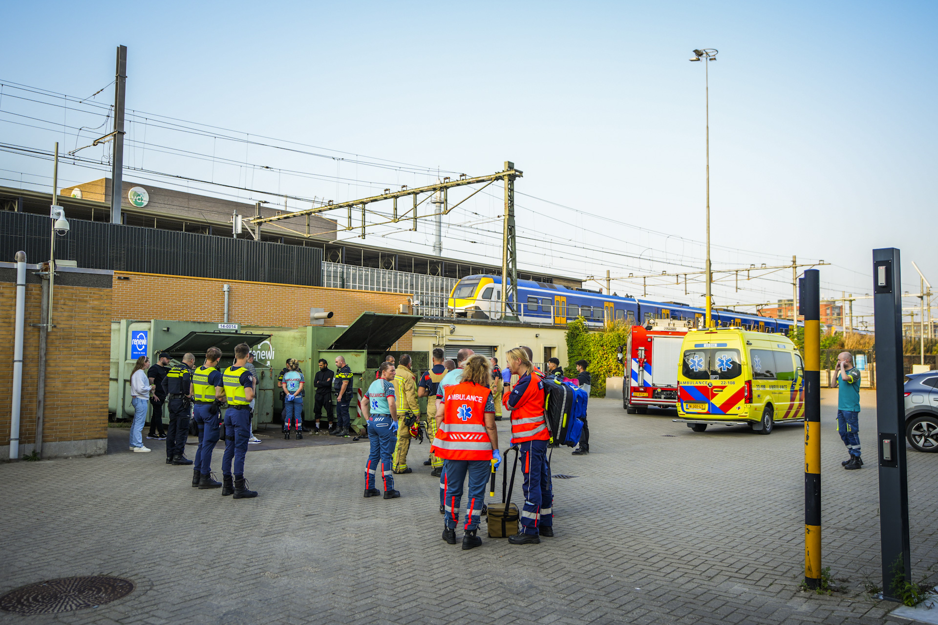 Man klimt in container met afvalpers bij station Eindhoven, hulpdiensten rukken massaal uit