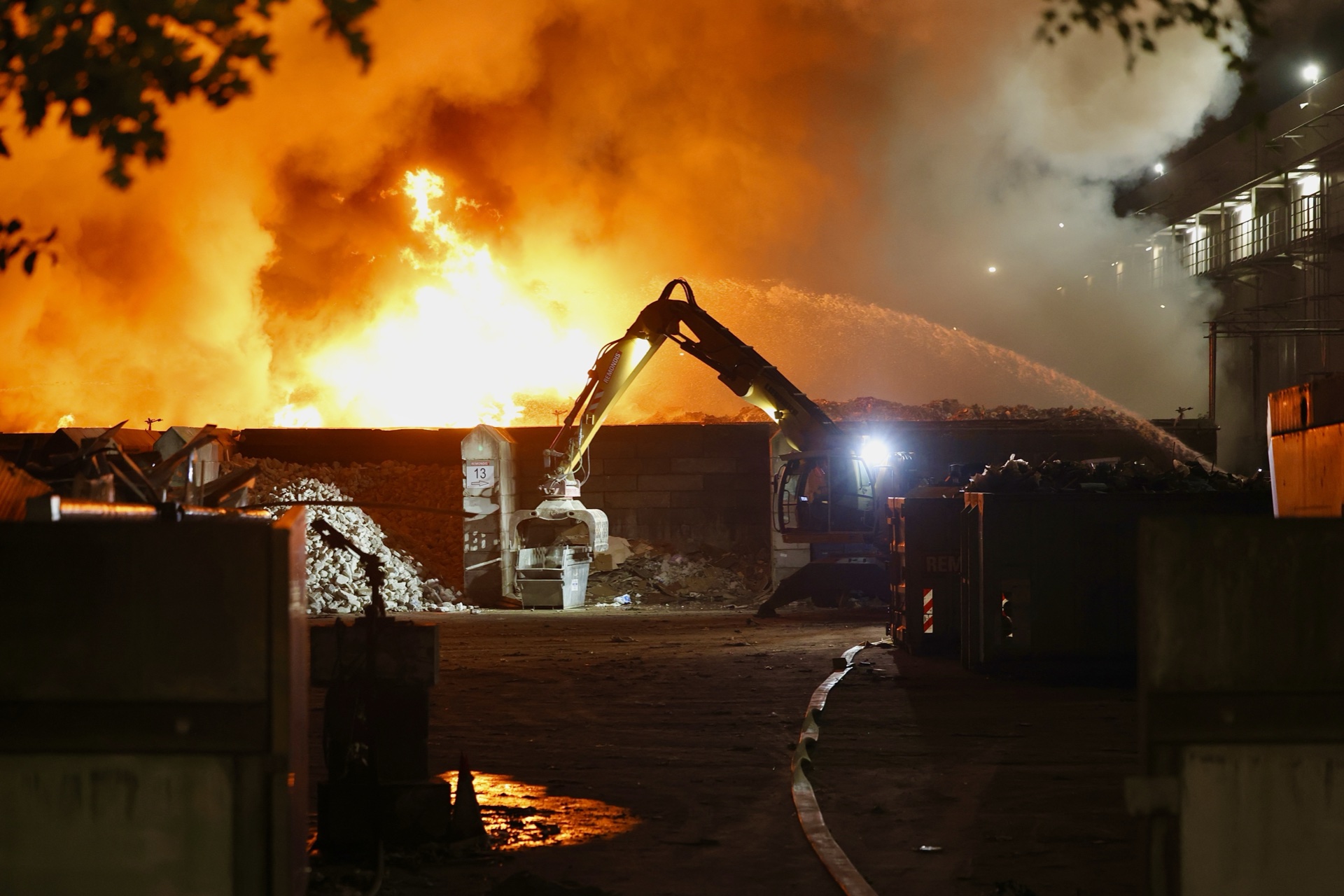 Grote berg afval in brand: metershoge vlammen, rook trekt over snelweg