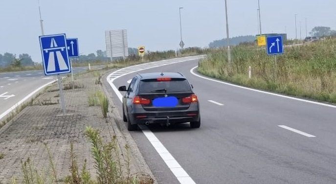Automobilist parkeert op toerit snelweg om op zijn laptop te werken