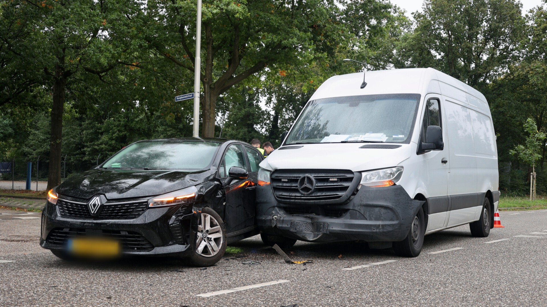 Busje en personenauto botsen op kruising