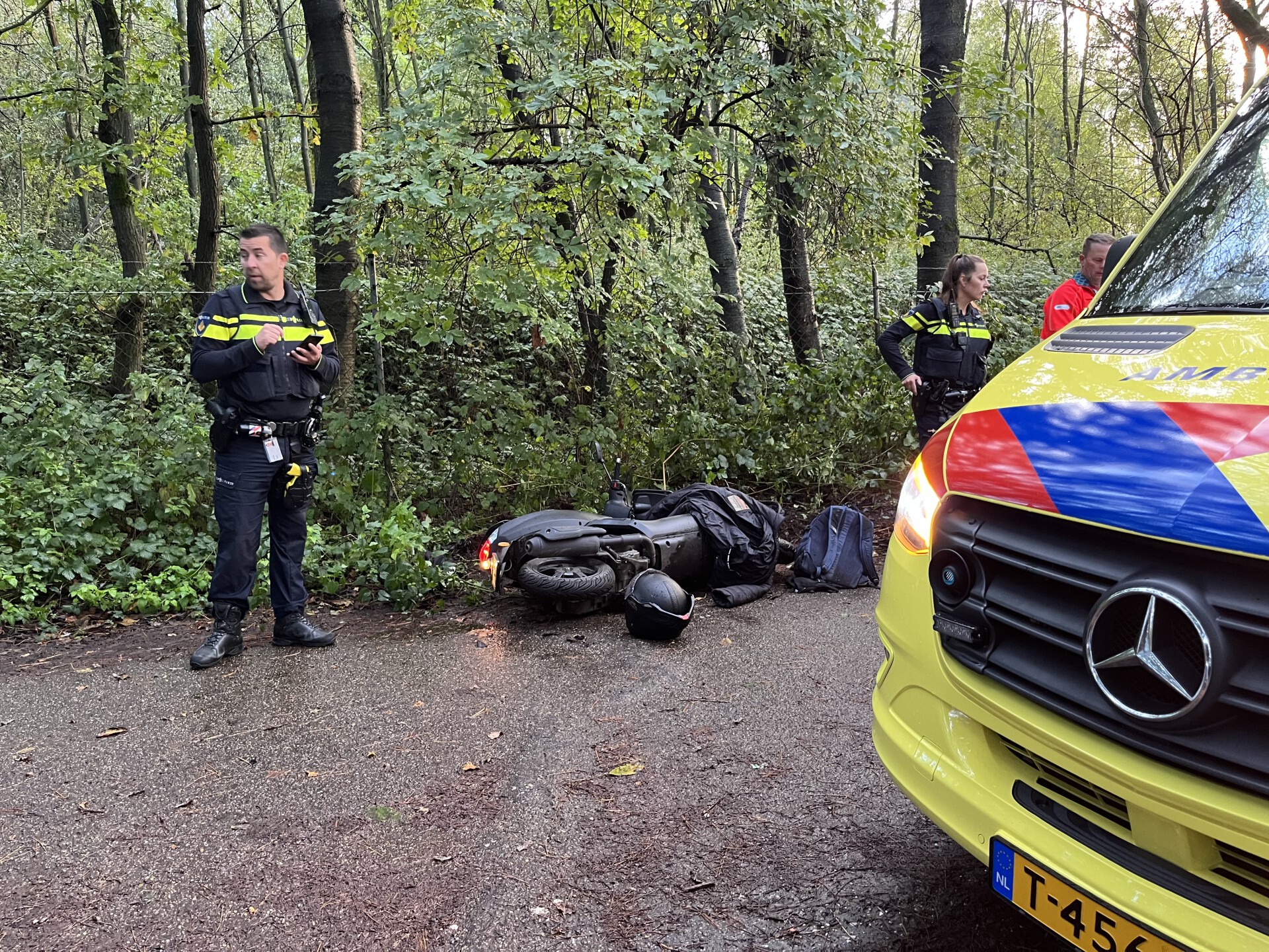 Scooterrijder gewond door val, mogelijk uitgegleden over natte bladeren