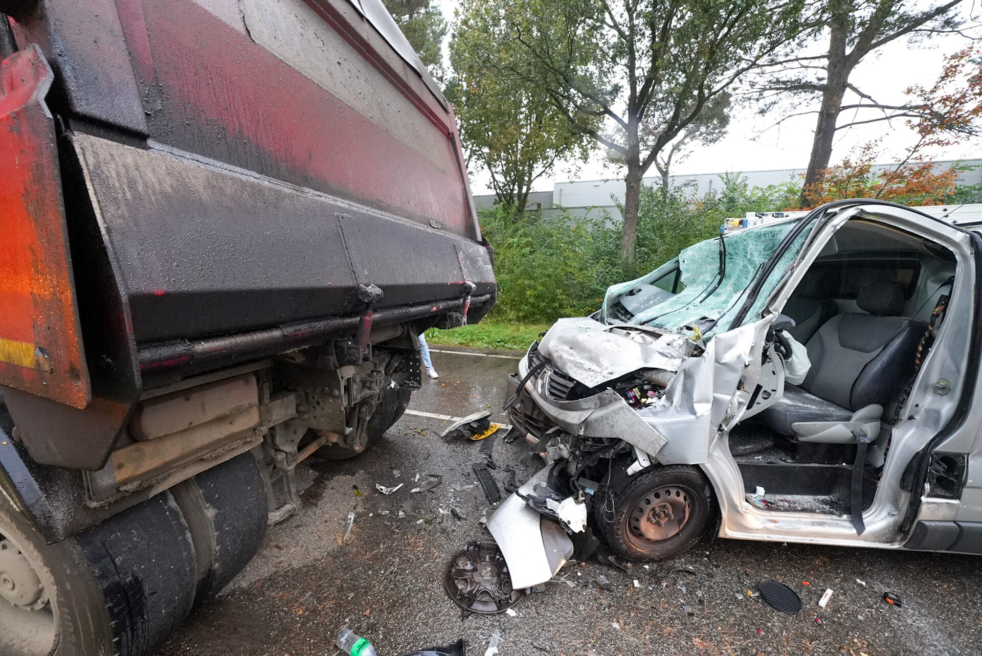 Bestelbus botst tegen geparkeerde vrachtwagen, bestuurder bekneld