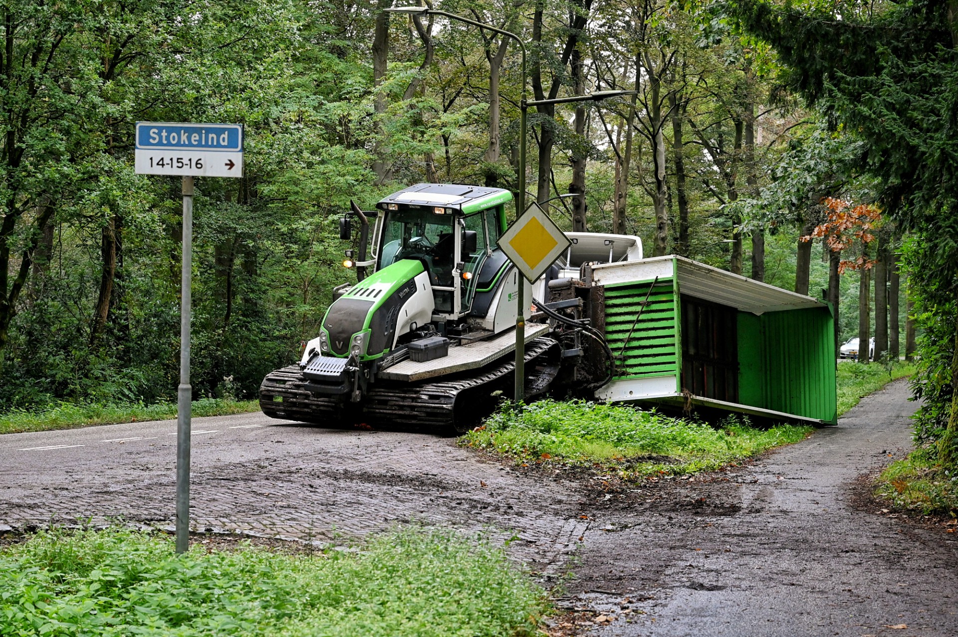 Aanhanger met rupsbanden valt van oplegger