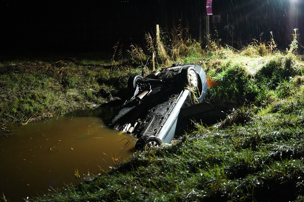 Auto belandt ondersteboven in sloot en drijft tientallen meters terug