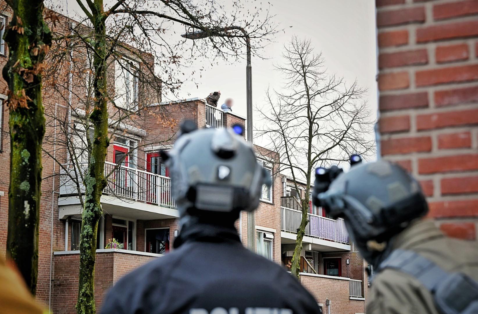 Mannen gooien stenen en zelfs een hakbijl vanaf dak, politie trekt wapens