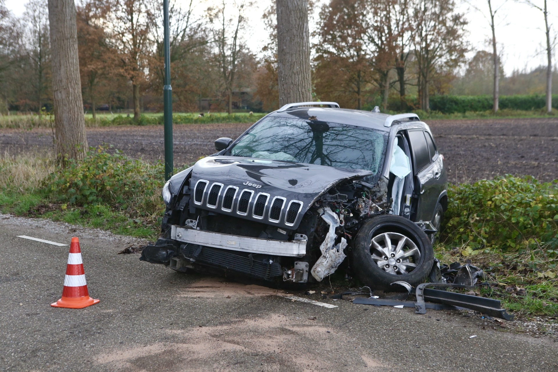 Automobilist bekneld na botsing tegen boom
