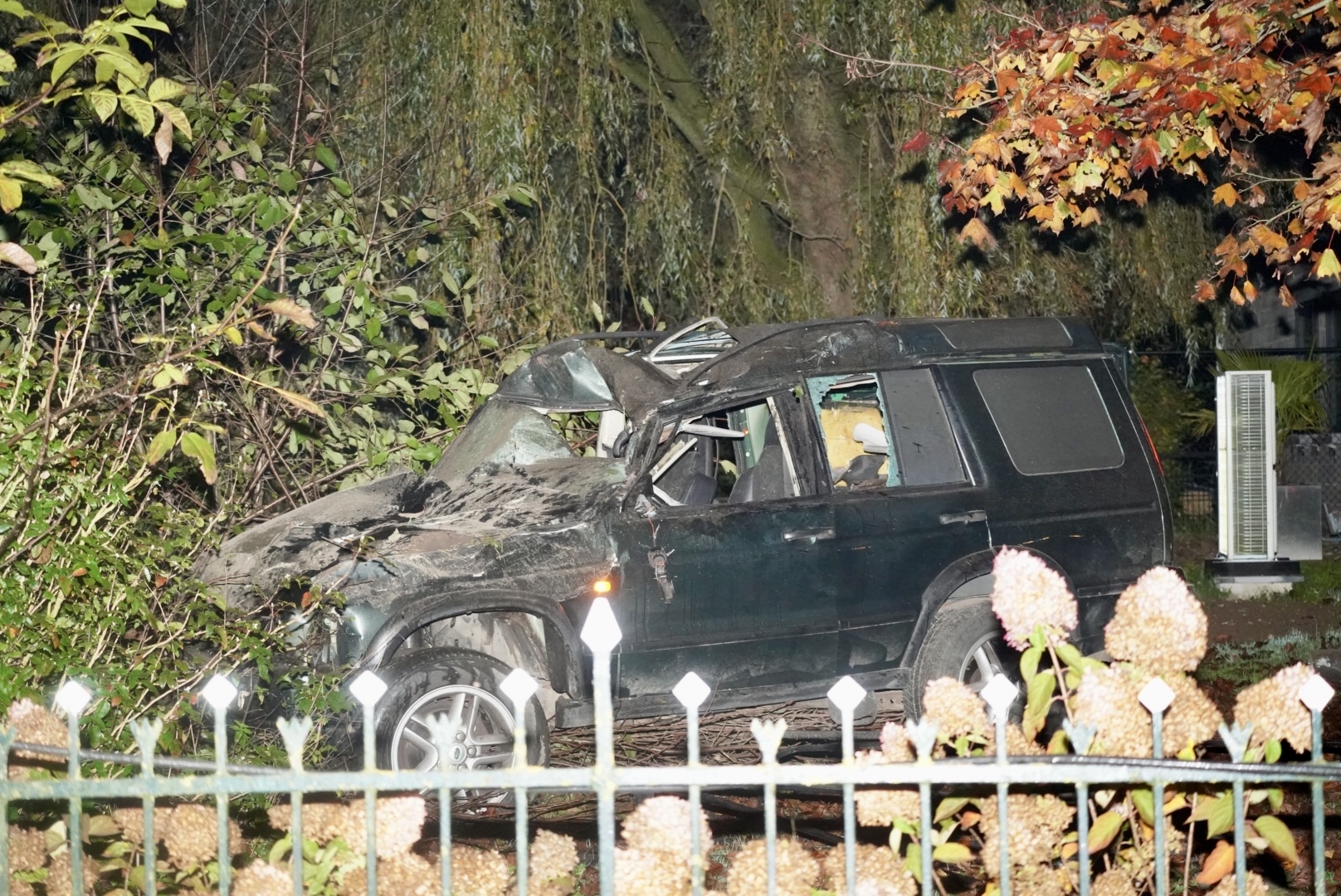 Auto ramt lantaarnpaal en belandt in voortuin, bestuurder gewond