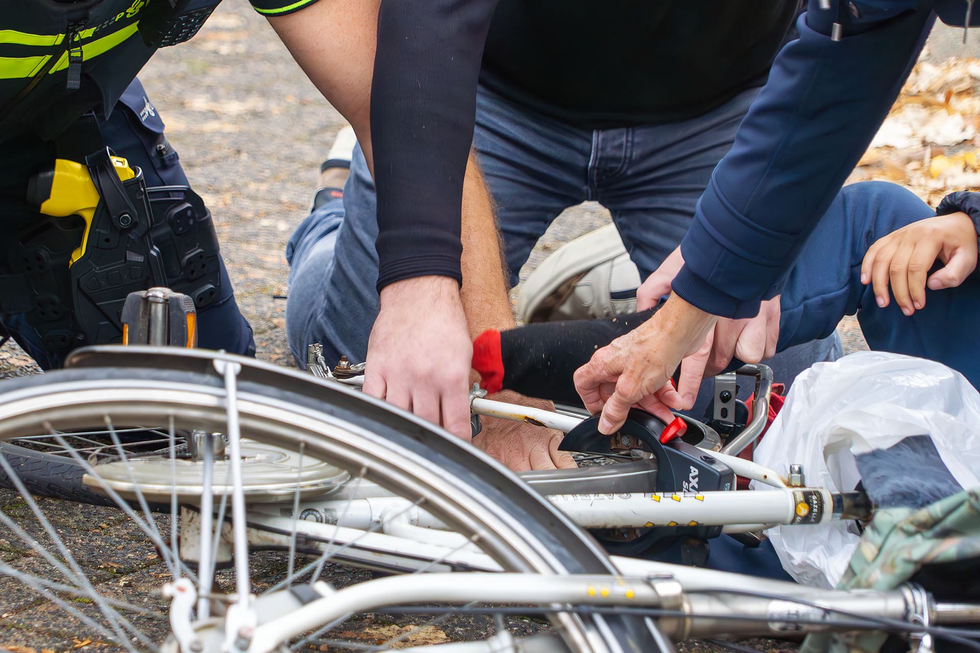 Jongetje met voetje tussen spaken fiets