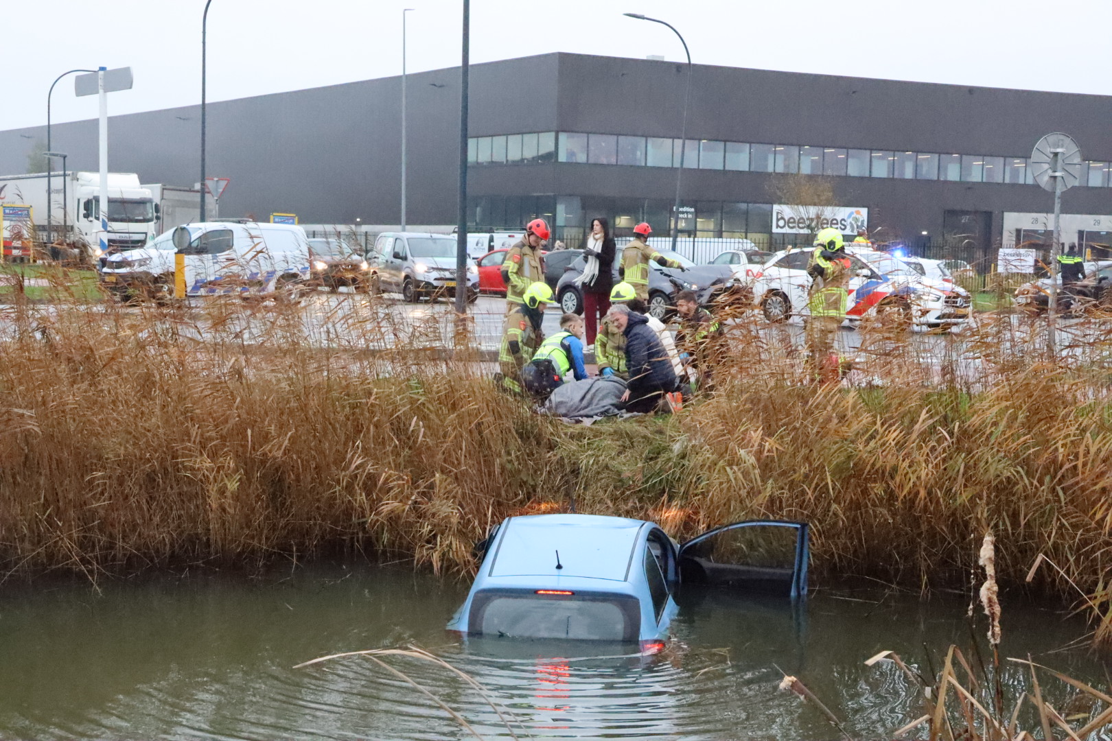 Auto in sloot na botsing op kruising, bestuurder gewond