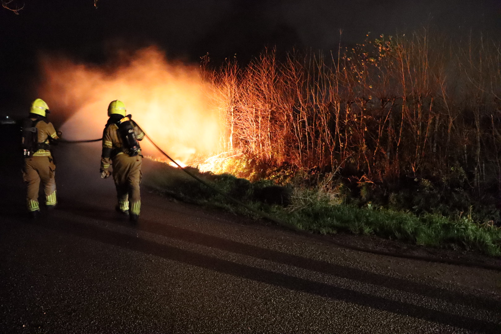 Grote stapel autobanden in brand gestoken