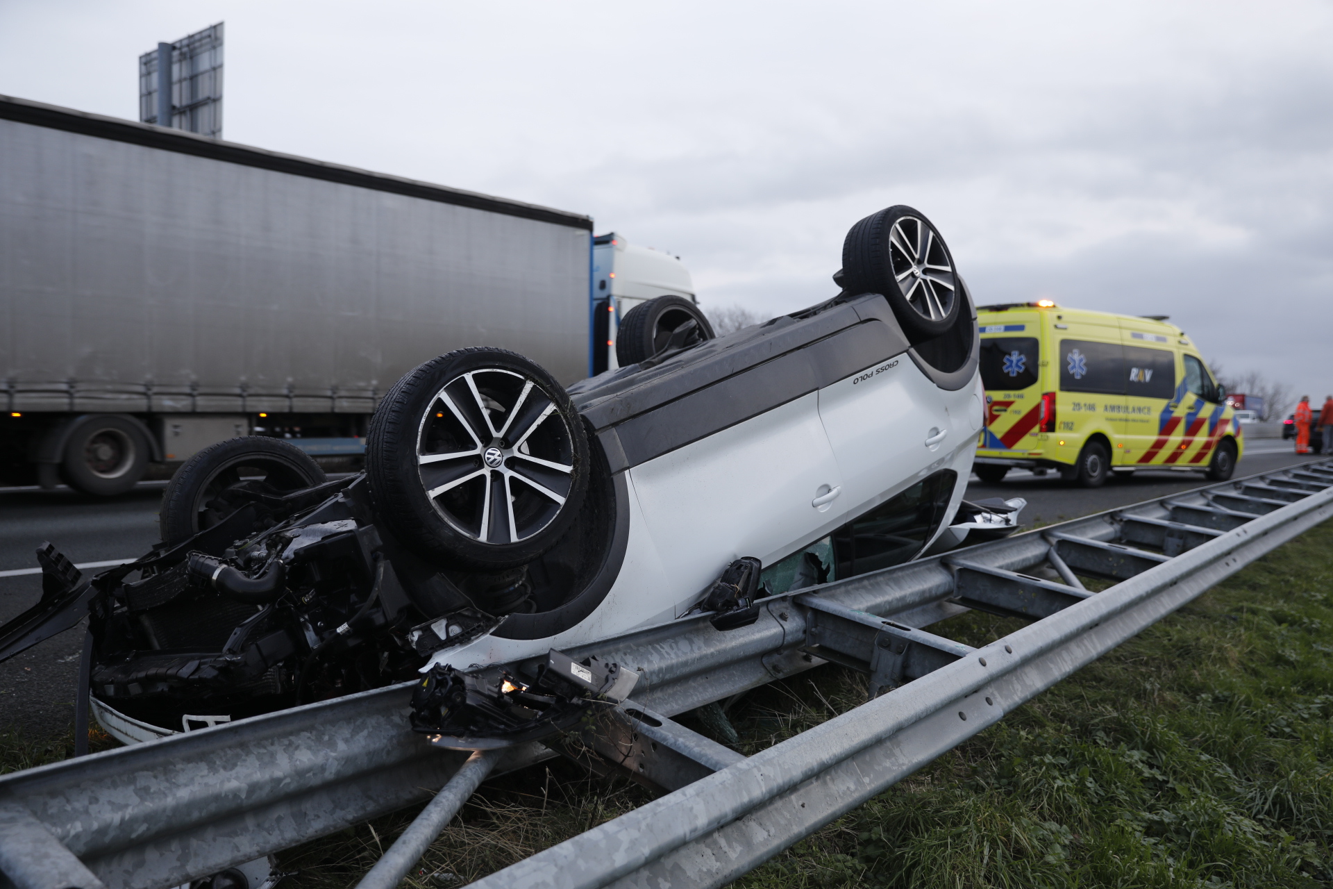 Auto komt ondersteboven op de vangrail van de snelweg terecht na botsing