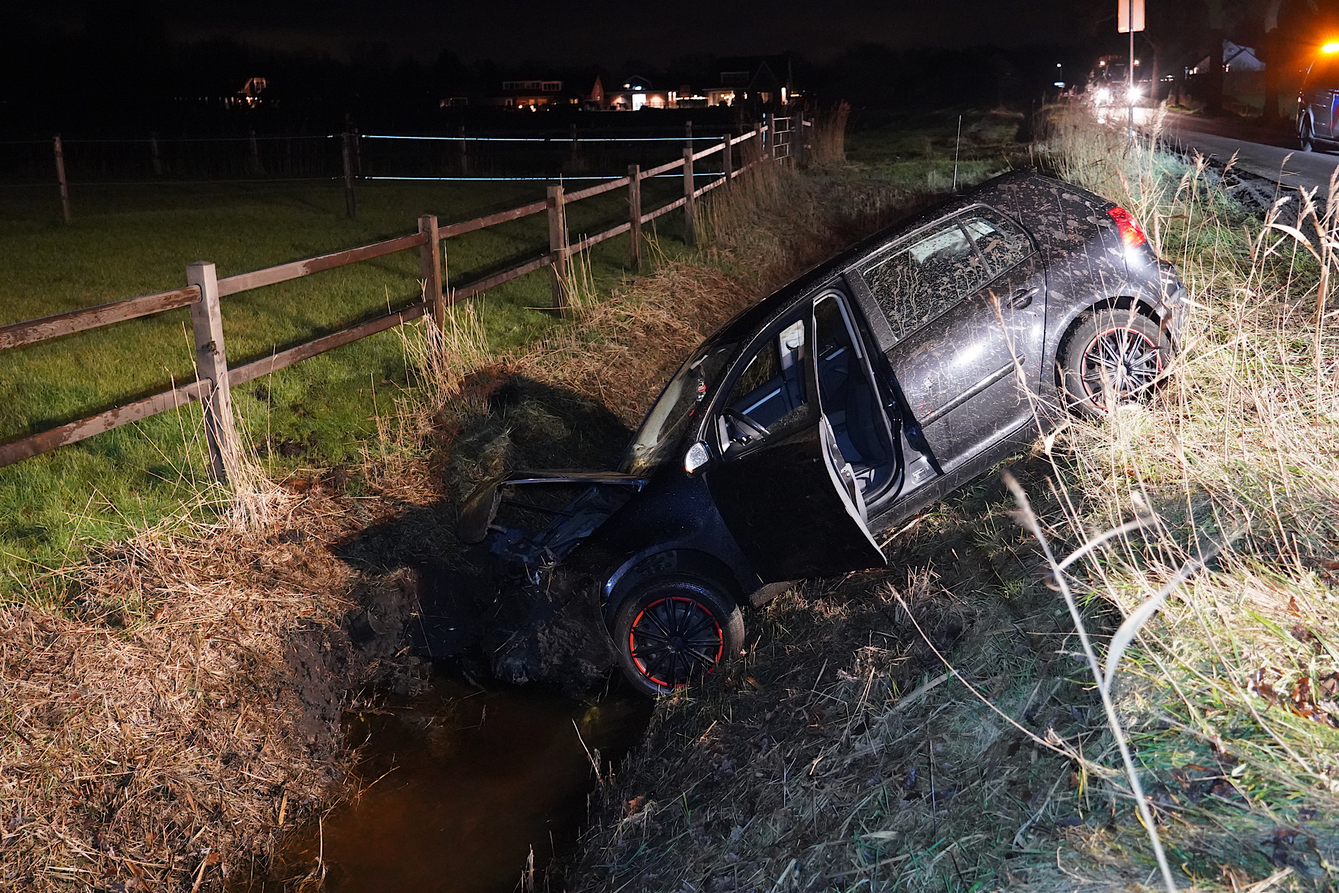 Auto rijdt sloot is door modderige weg