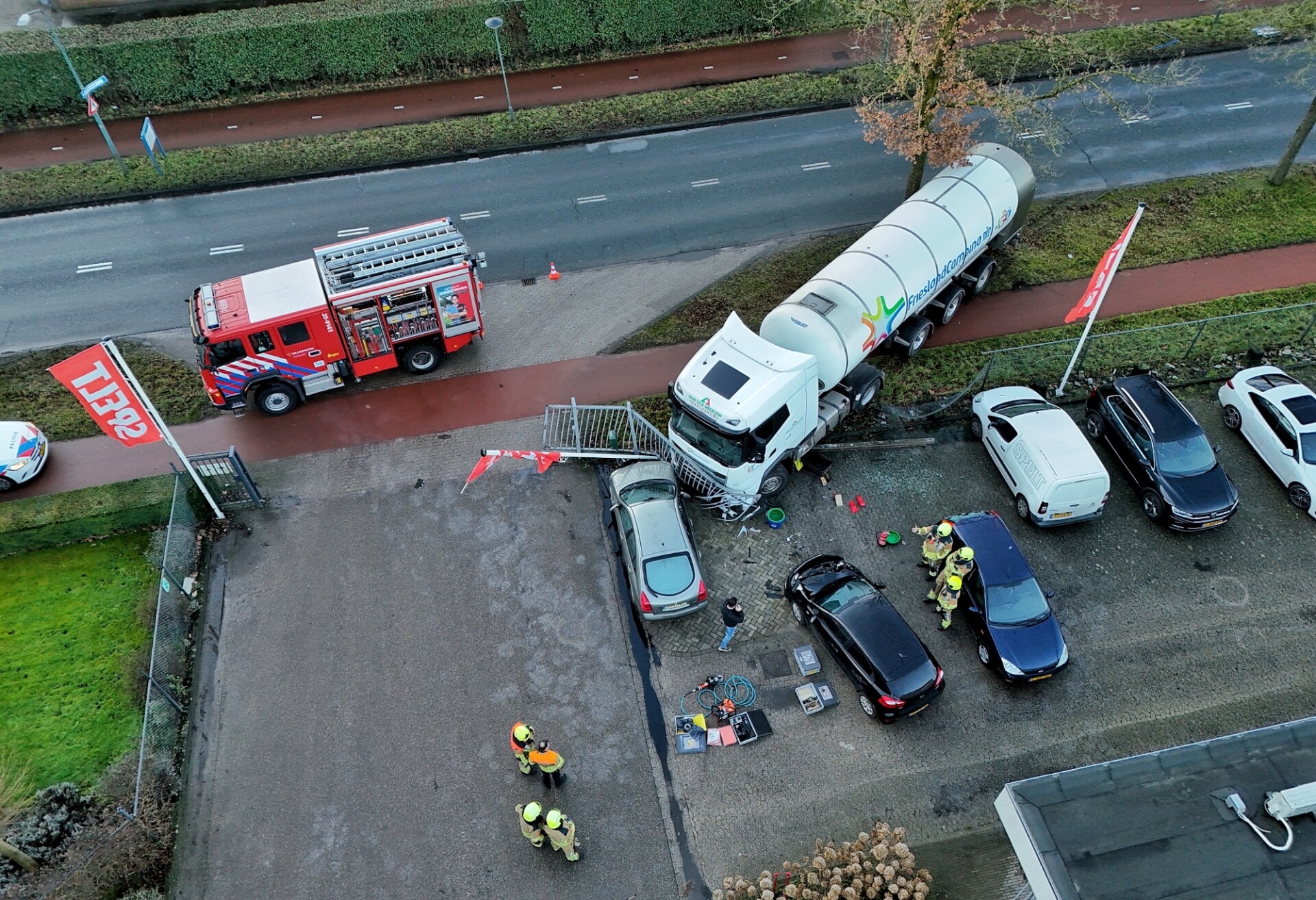 Vrachtwagen rijdt dwars door hek heen en ramt drie geparkeerde auto’s