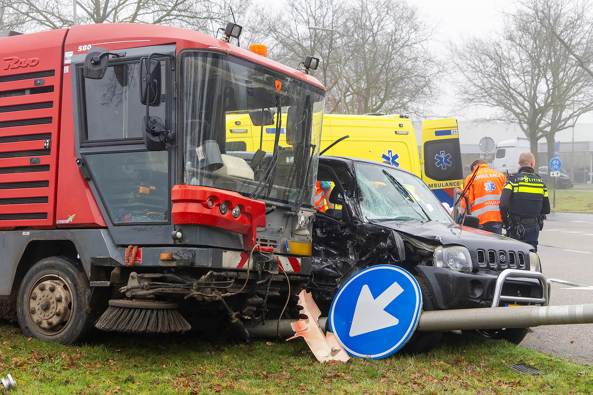 Veegwagen en auto botsen, automobilist gewond