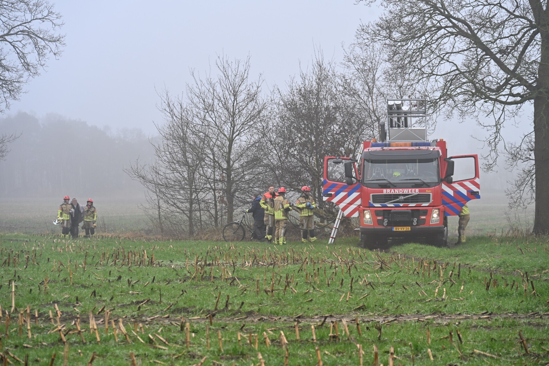 Man vast in drijfzand, omstander met hond schiet te hulp