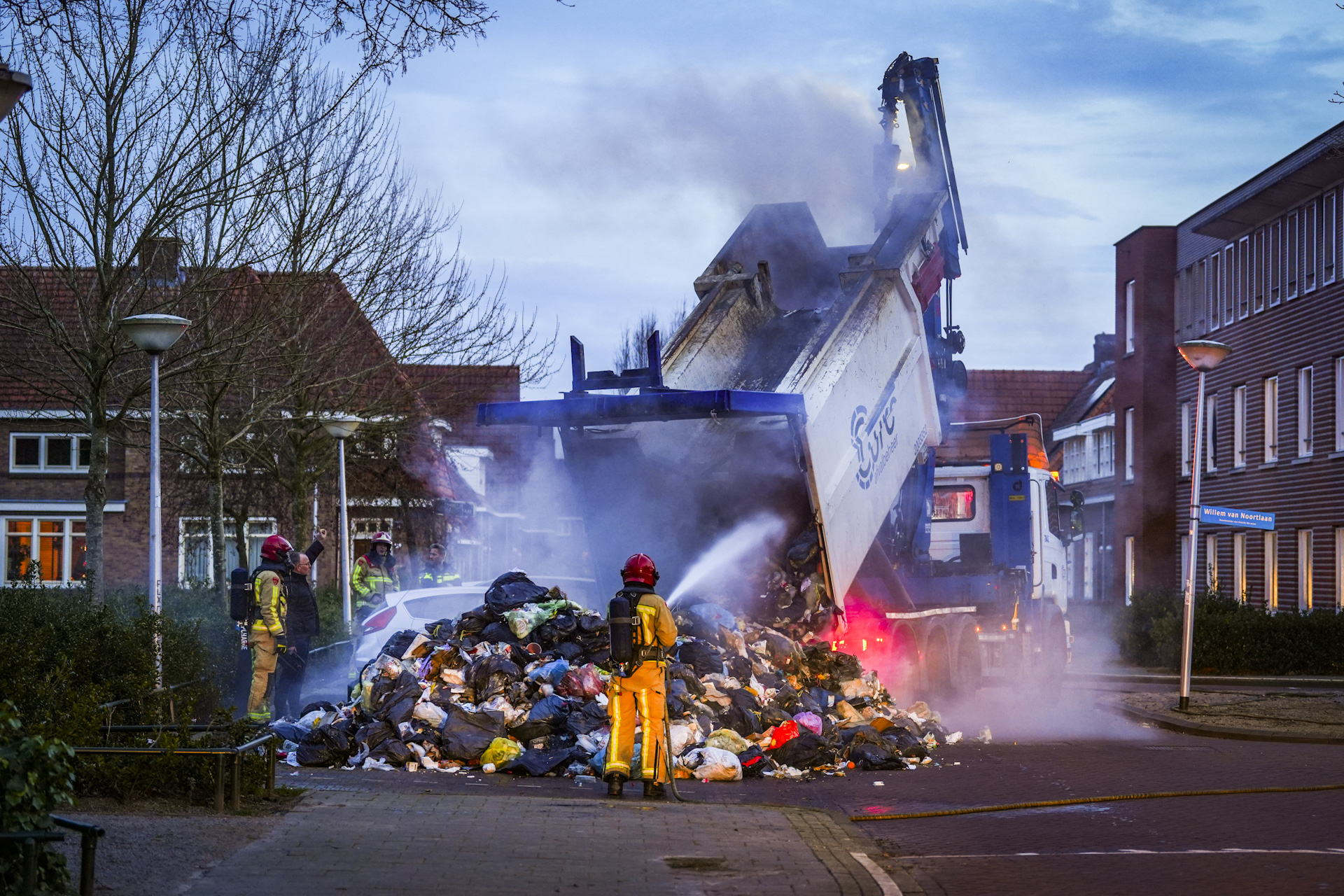 Brand in vuilniswagen, vuilnis wordt op straat gekieperd