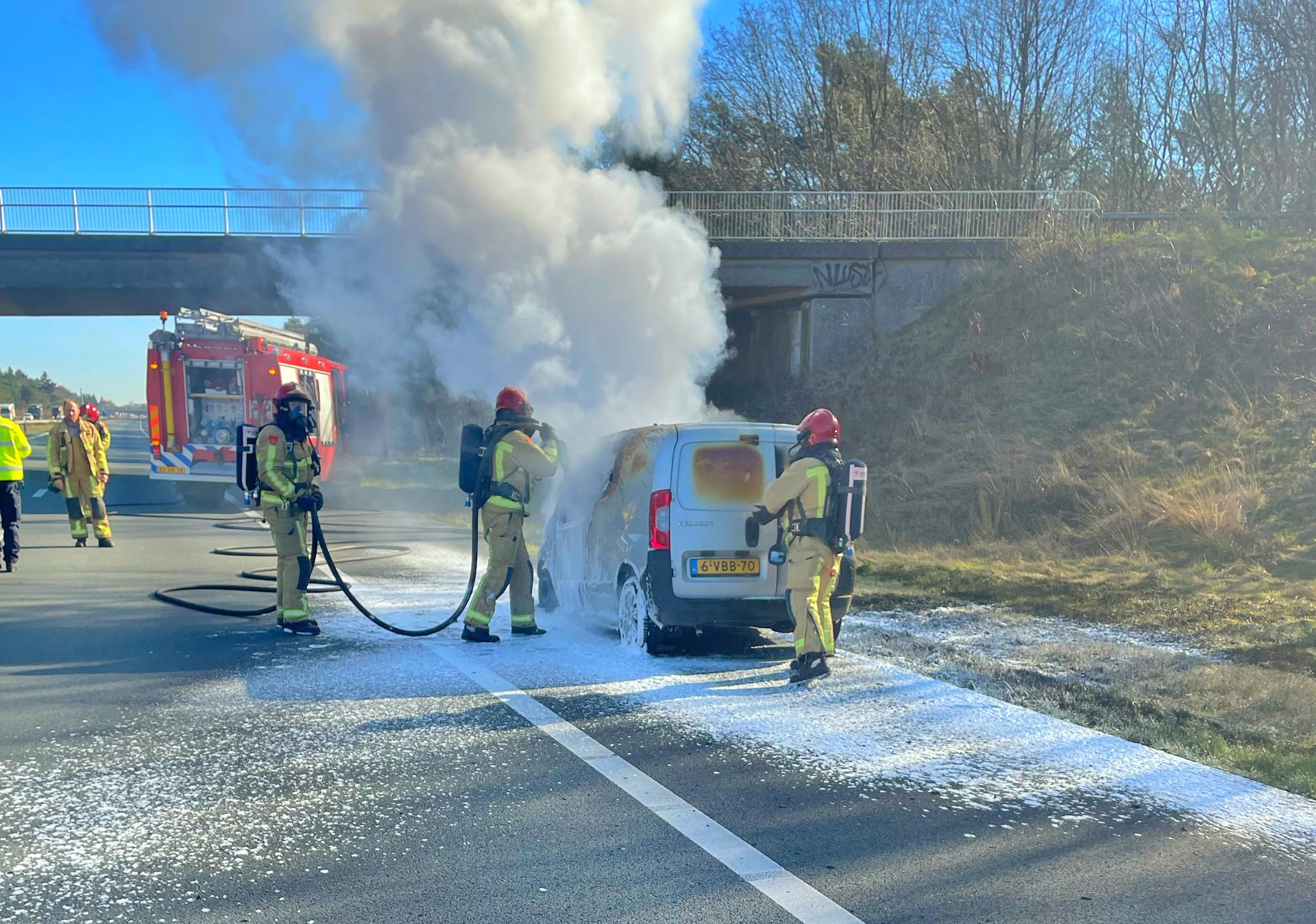 Lange file door brandende bestelwagen op A67