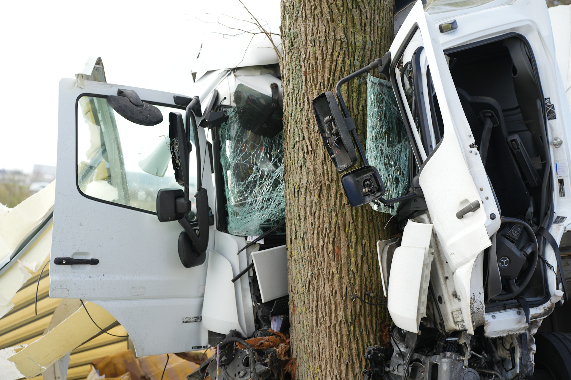 Vrachtwagenchauffeur bekneld en zwaargewond na botsing tegen boom