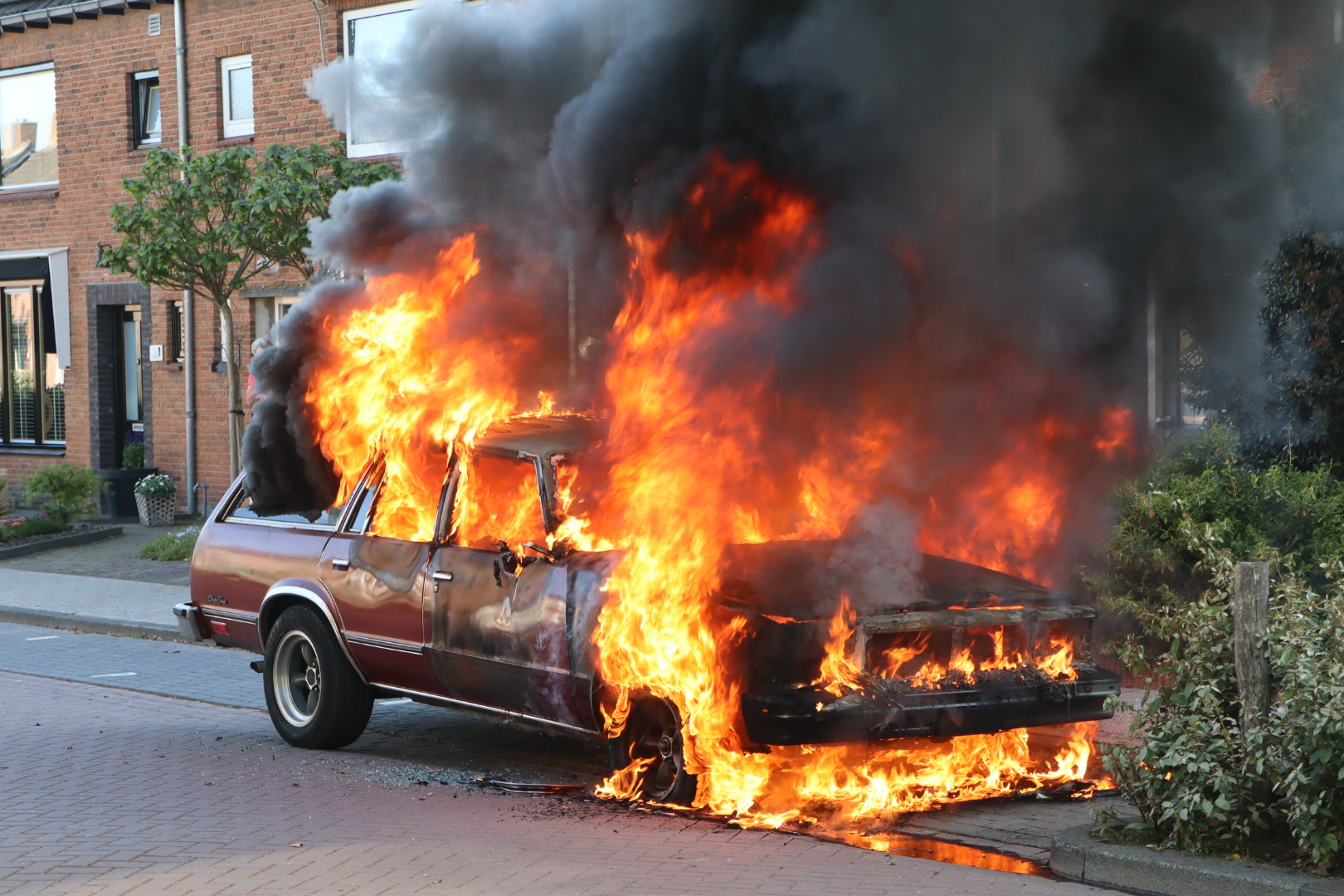 Oldtimer gaat in vlammen op, zwarte rookwolk trekt over woonwijk