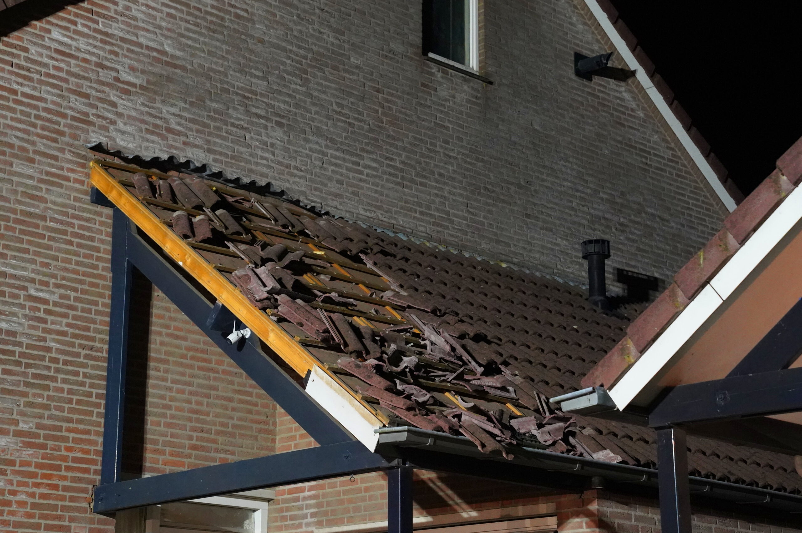 Dakpannen op straat door explosie bij woning