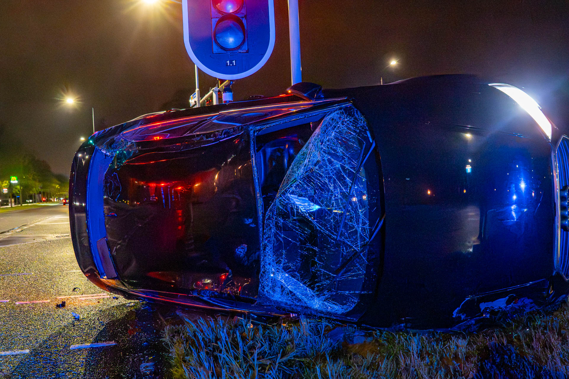 Auto op z’n kant na botsing tegen verkeerslicht