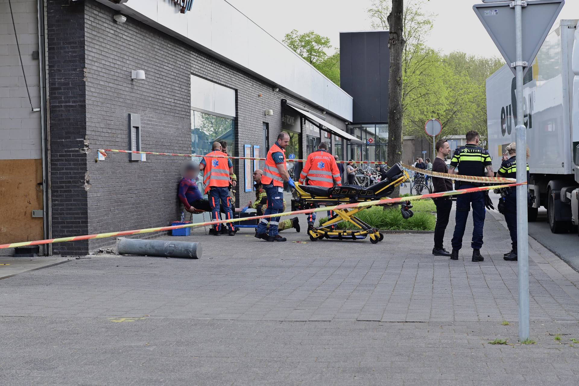 Vrachtwagen rijdt tegen gevel supermarkt
