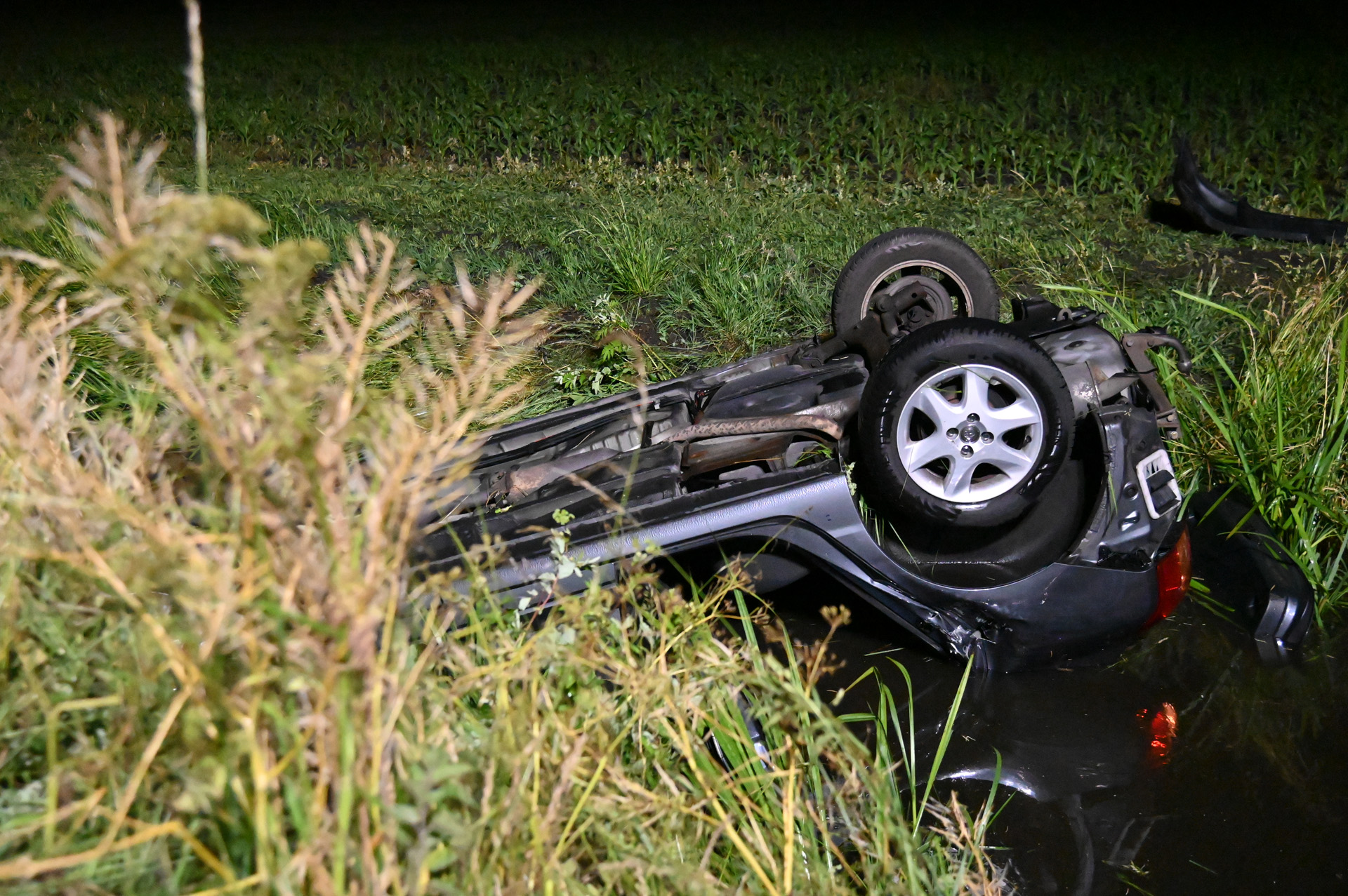 Auto op z’n kop in sloot, hulpdiensten massaal uitgerukt