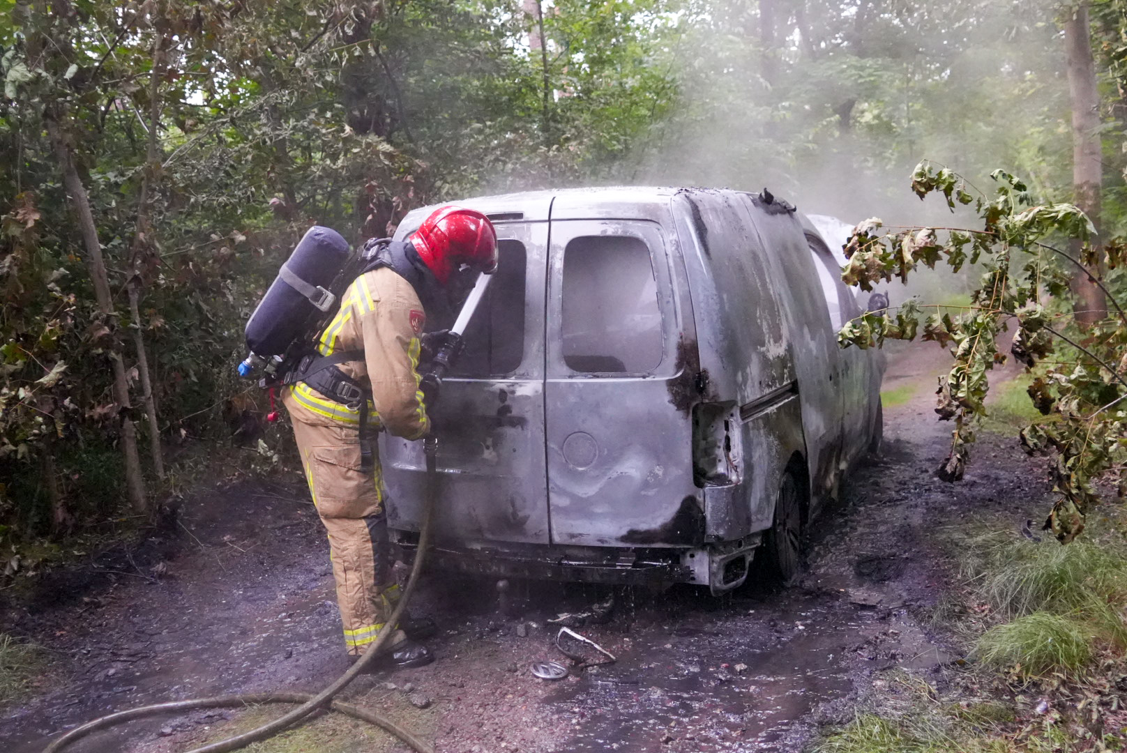 Brandende bestelbus op bospad aangetroffen