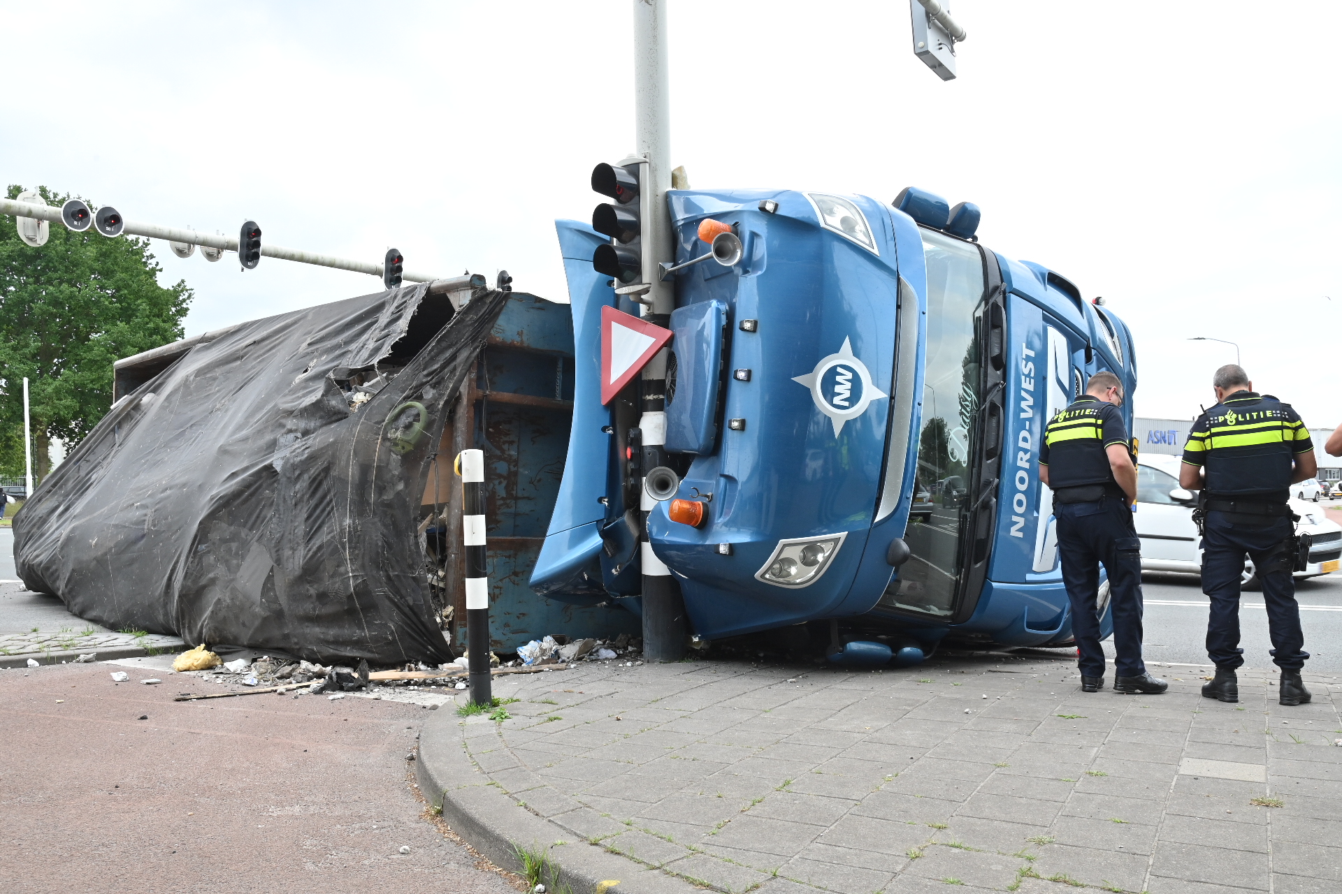 Vrachtwagen kantelt op kruispunt