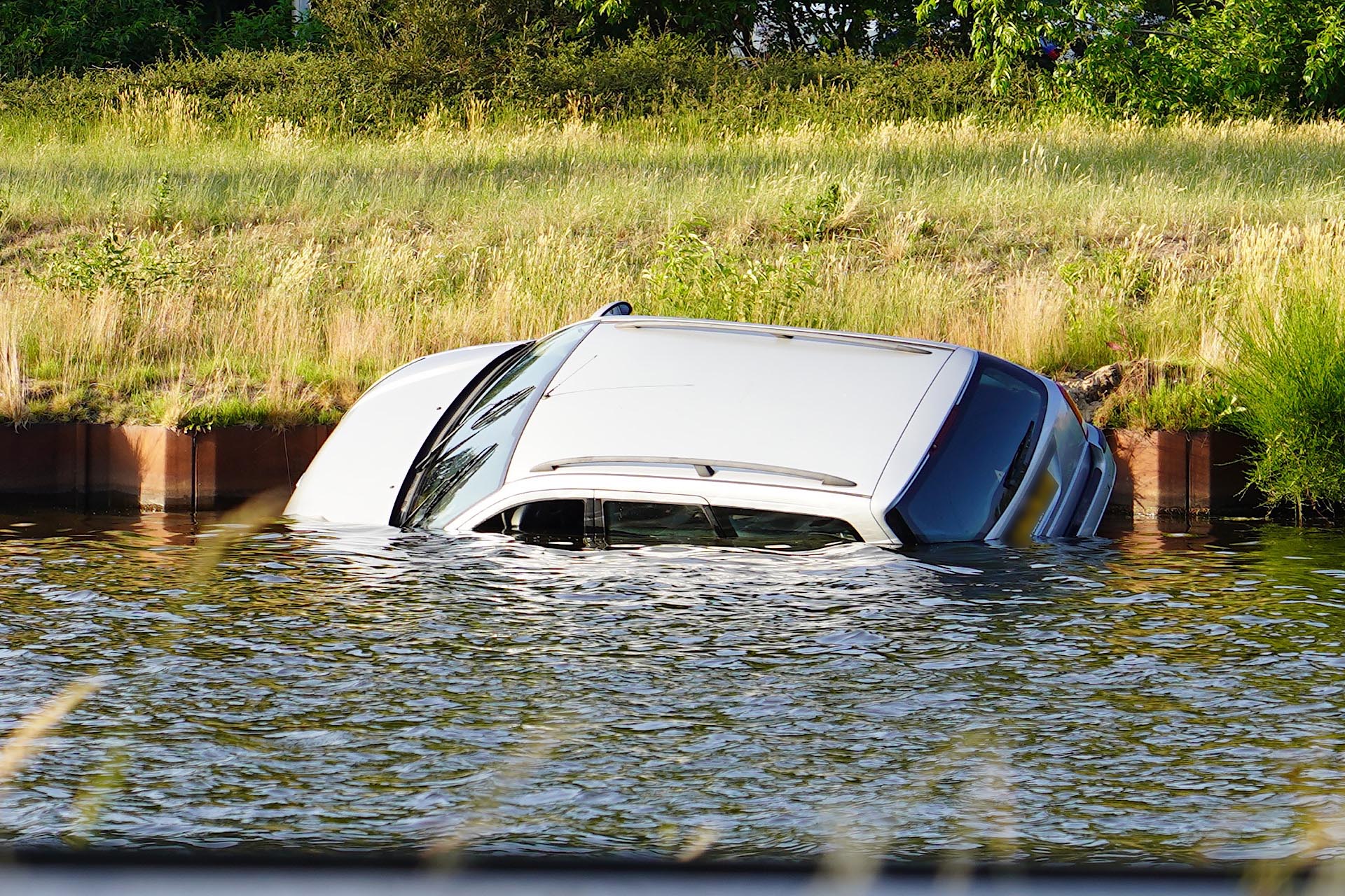 Automobilist verliest controle over het stuur en belandt met auto in kanaal