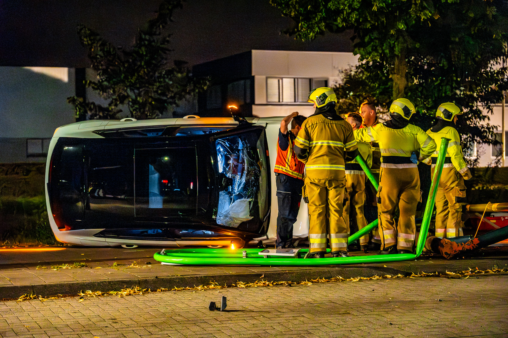 Auto raakt lantaarnpaal en belandt op zijkant