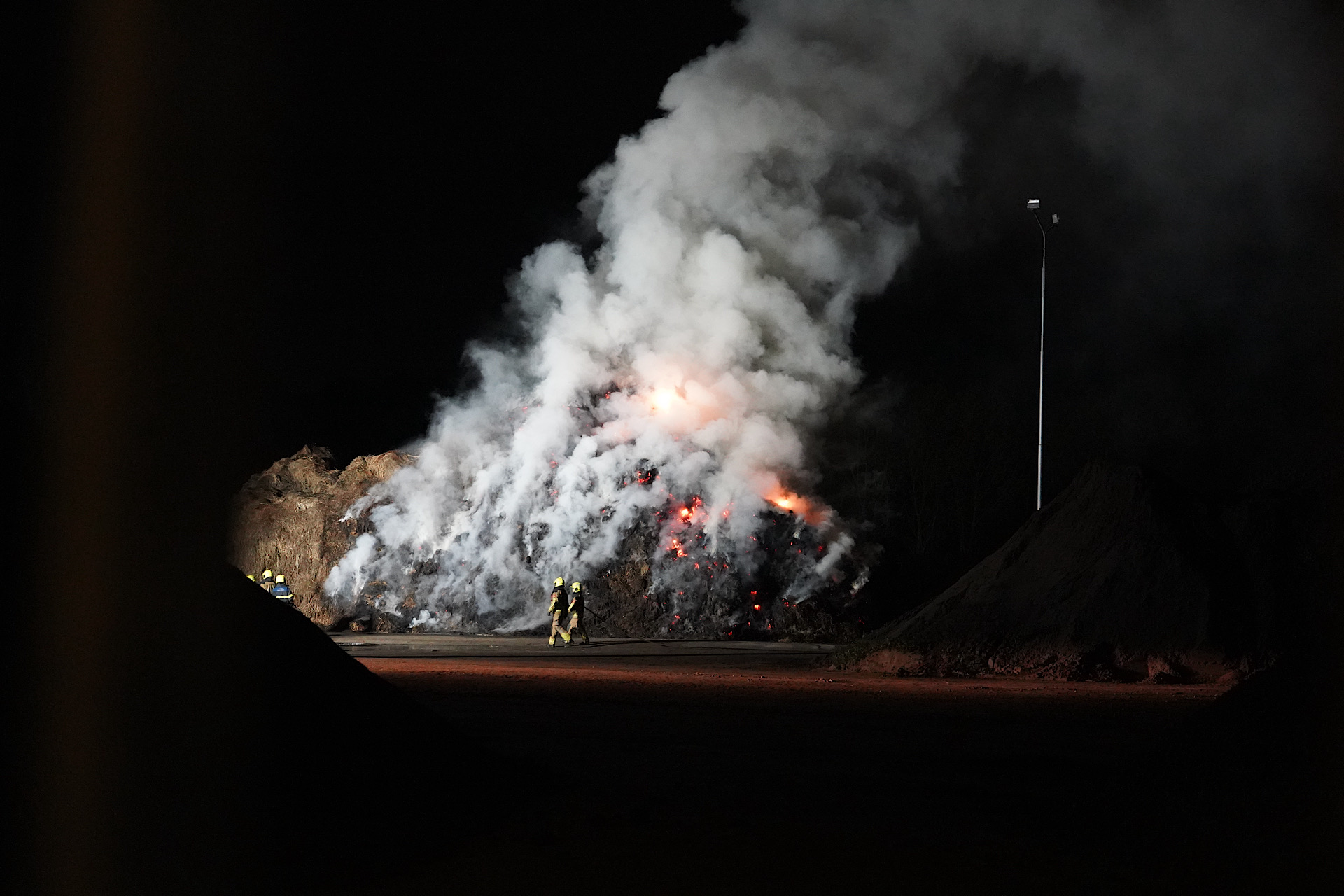 Grote berg maaisel in brand, veel rook komt vrij