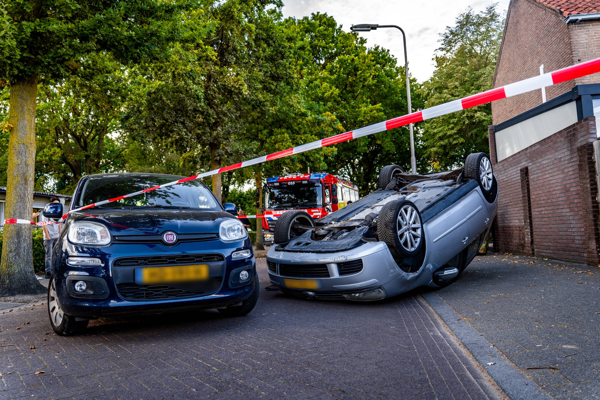 Auto slaat over de kop na botsing met geparkeerd voertuig
