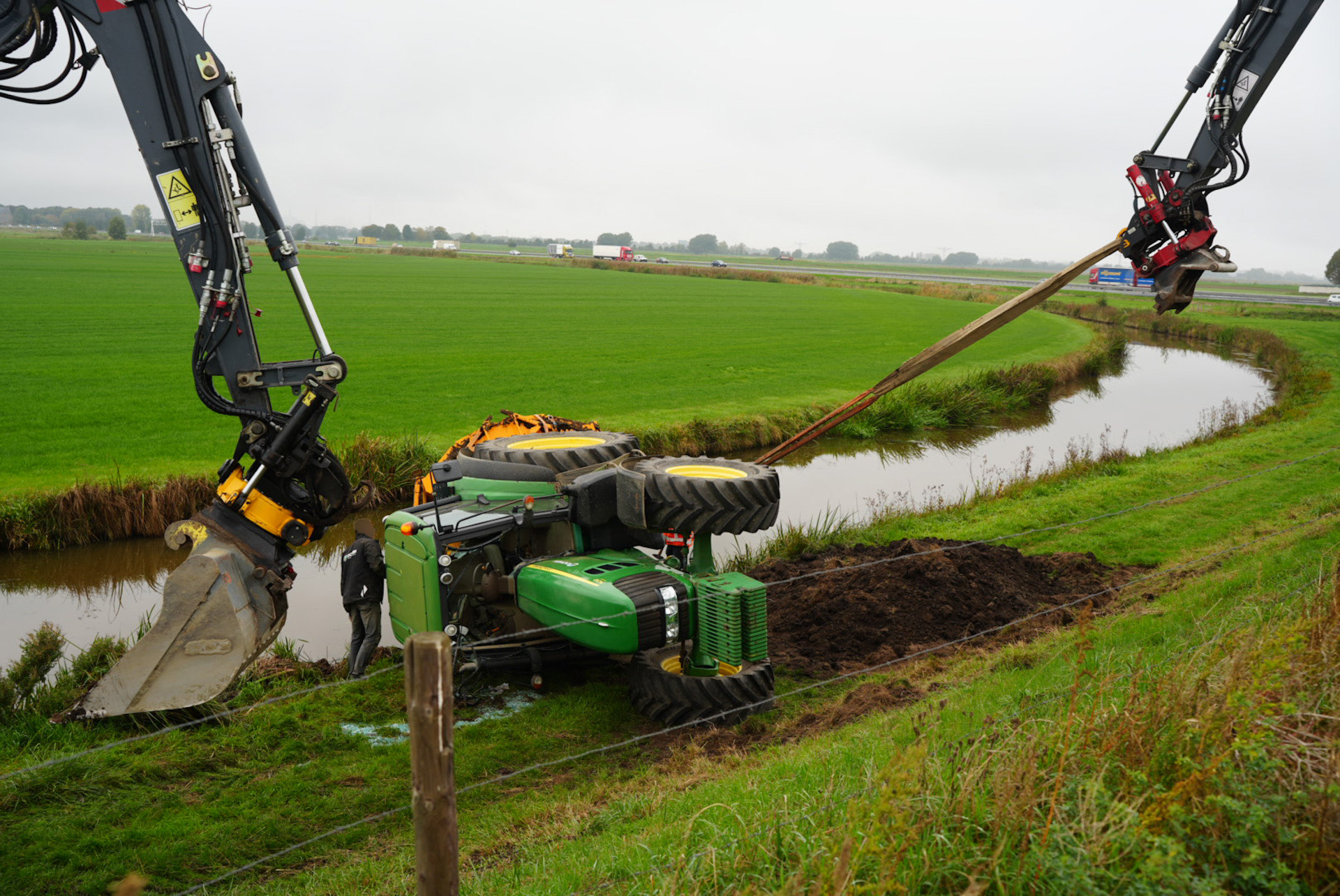 Tractor met aanhanger kantelt, kiepkar belandt in kanaal