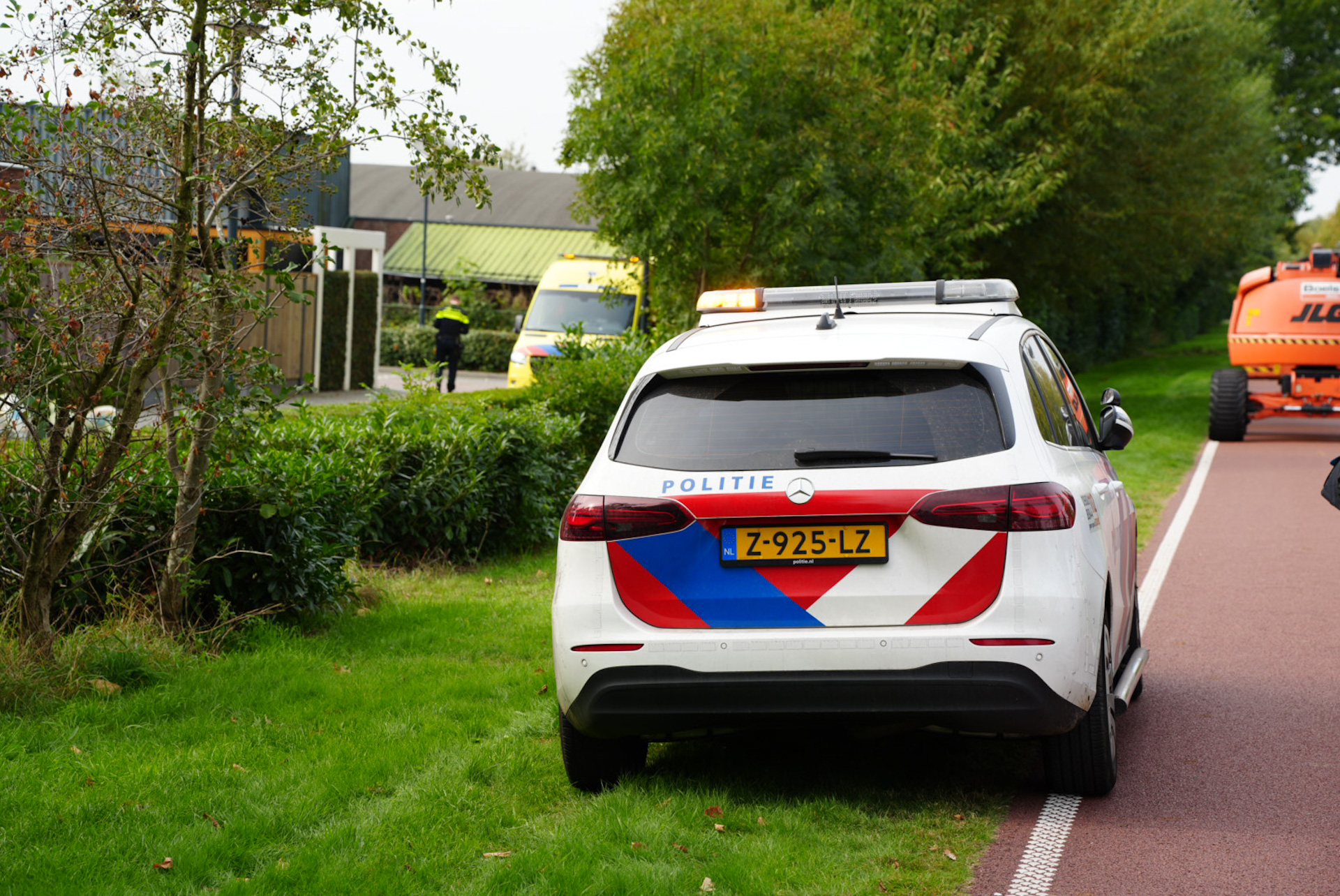 Man met fiets in sloot, door werklieden uit water gered