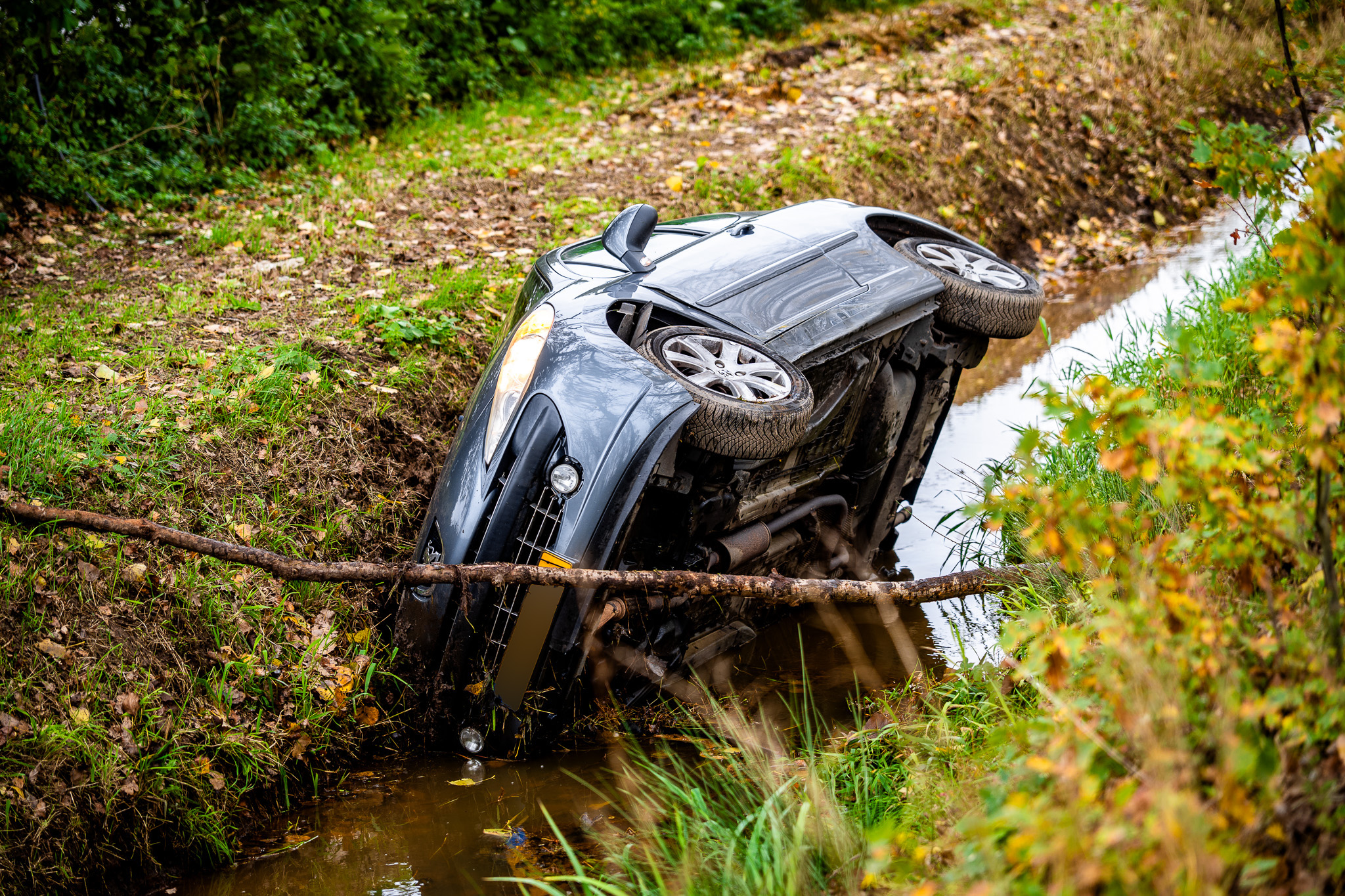 Jonge automobilist raakt van zandpad en belandt met auto in sloot