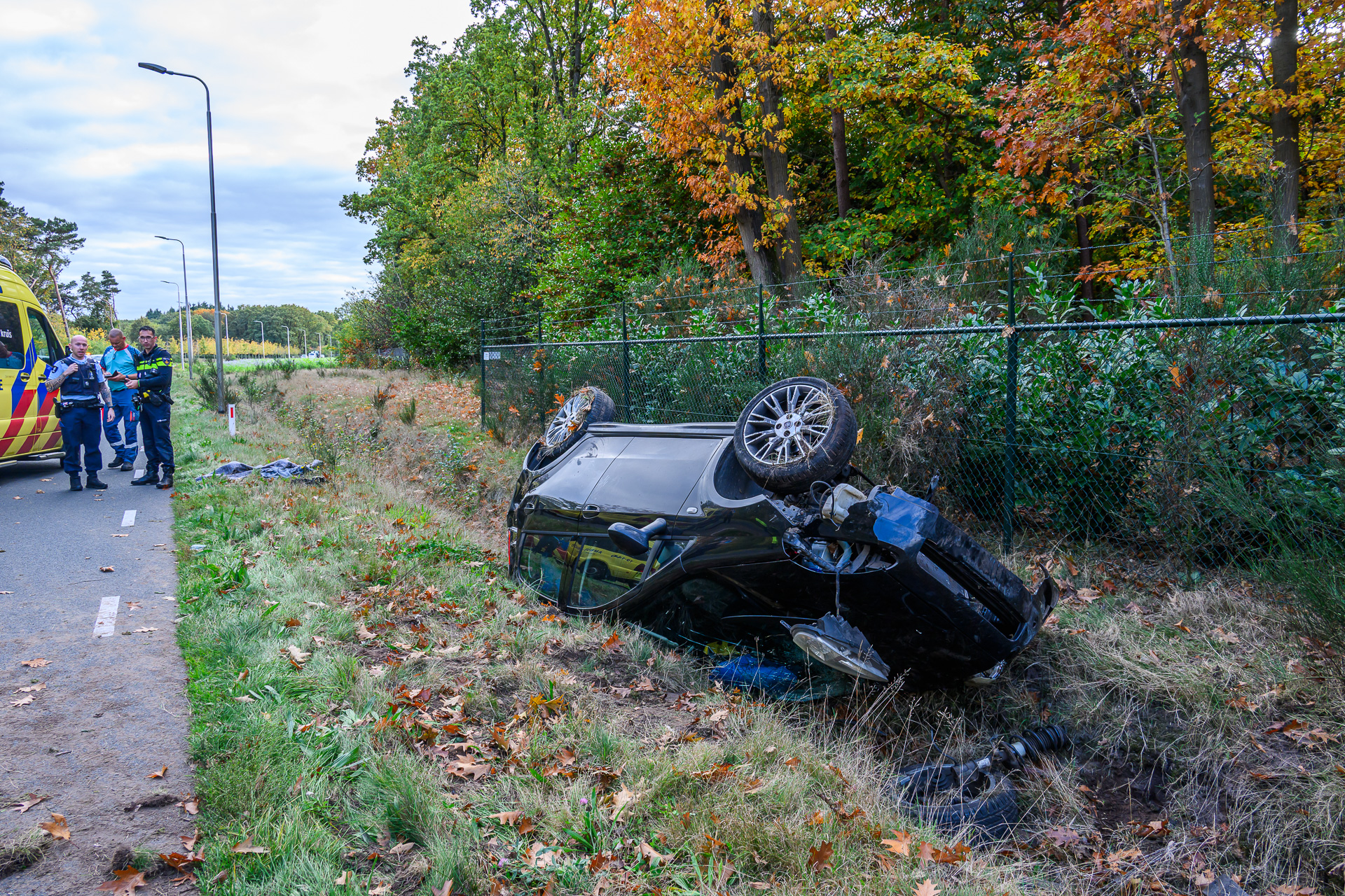 Auto belandt op de kop in sloot na botsing met lantaarnpaal