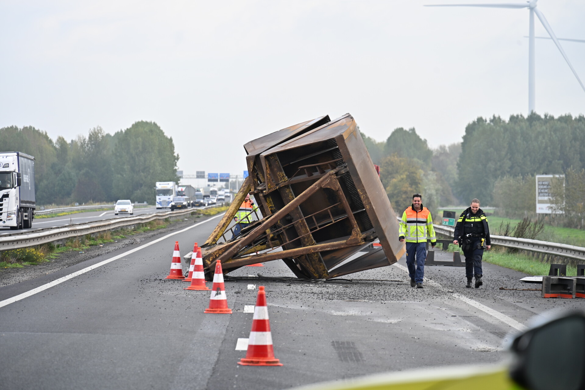Vrachtwagen verliest grote grijperbak op de snelweg, weg volledig dicht