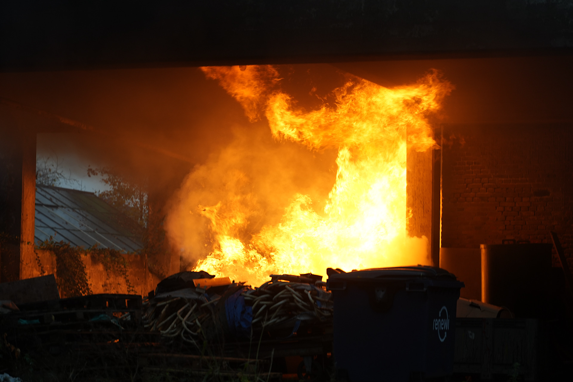 Afval in brand onder oude fabriek