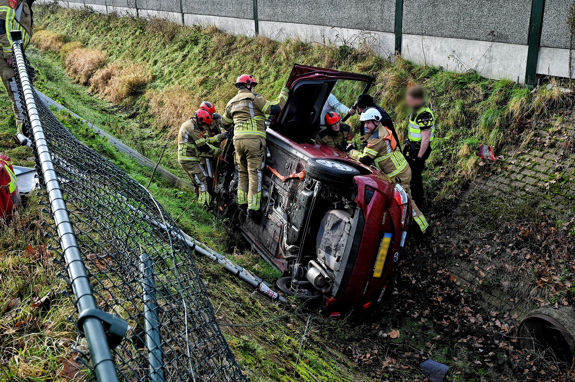 Auto belandt op zijkant in greppel, bestuurster gewond