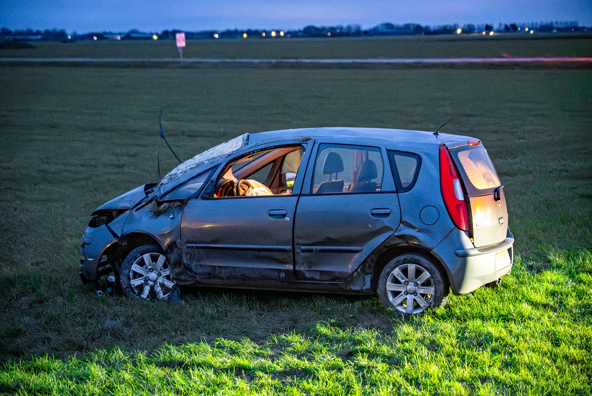 Auto raakt van de weg en belandt in weiland