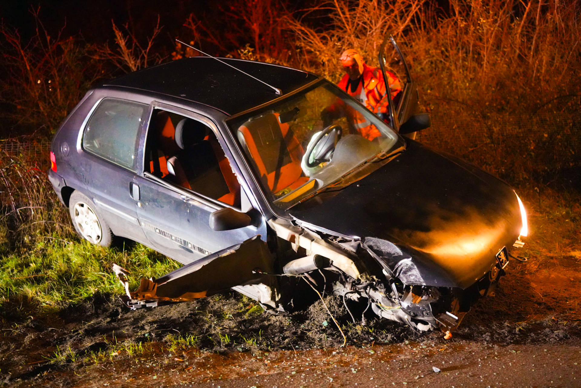 Auto slaat om na botsing met lantaarnpaal