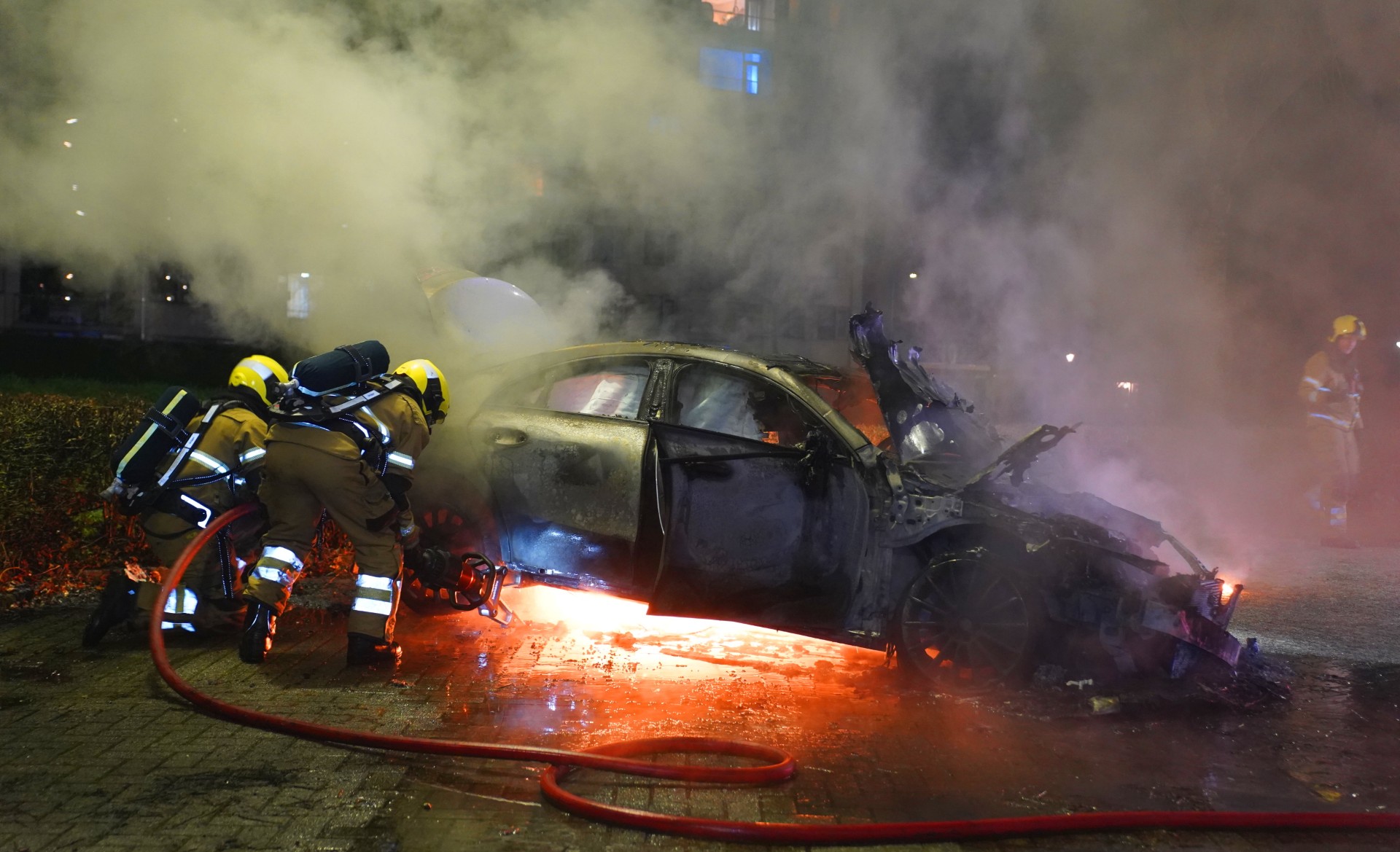 Mercedes brandt uit op parkeerplaats bij flat