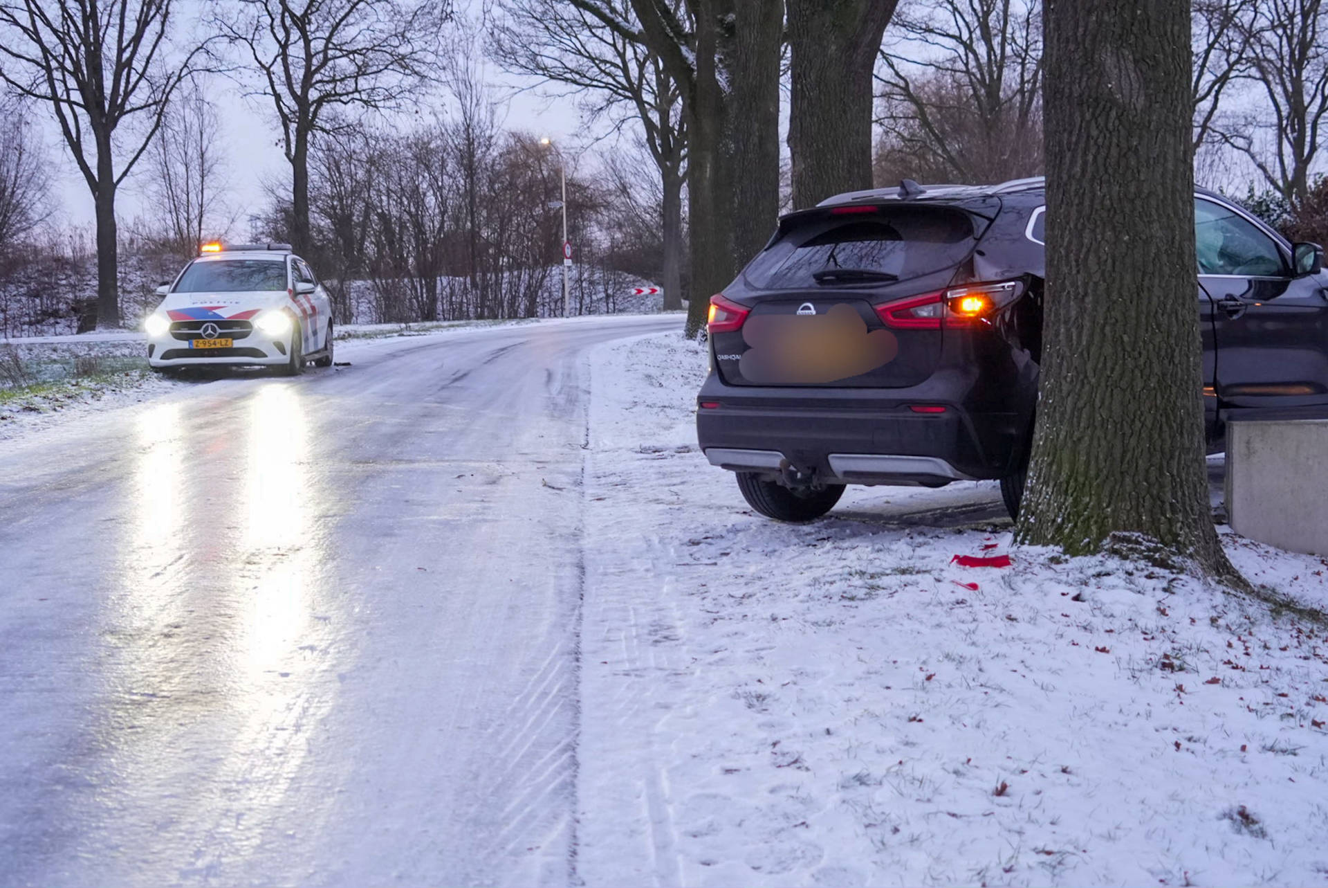 Auto raakt door gladheid van de weg en botst tegen boom