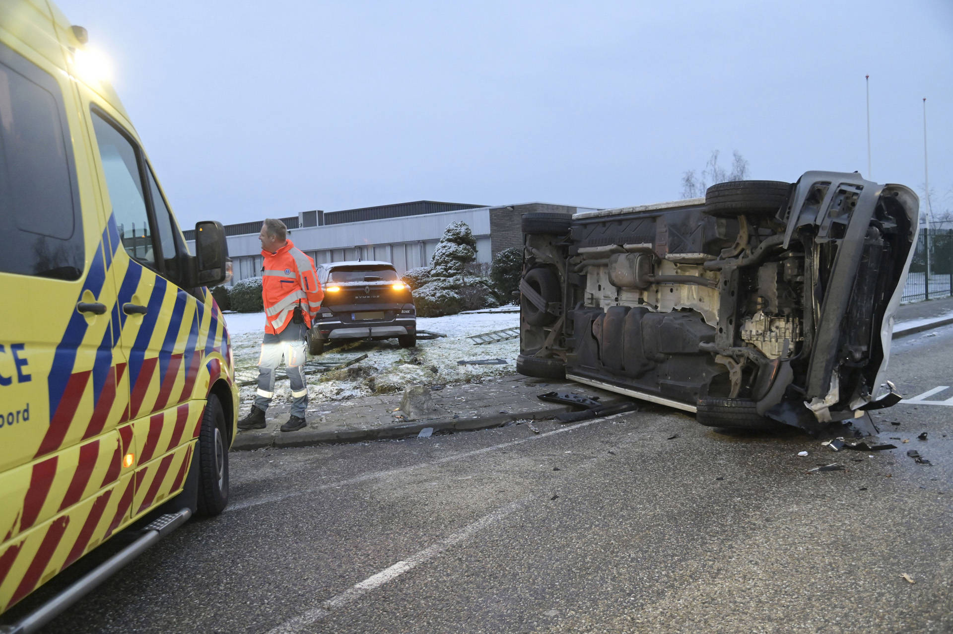 Busje op zijn zijkant na aanrijding met auto