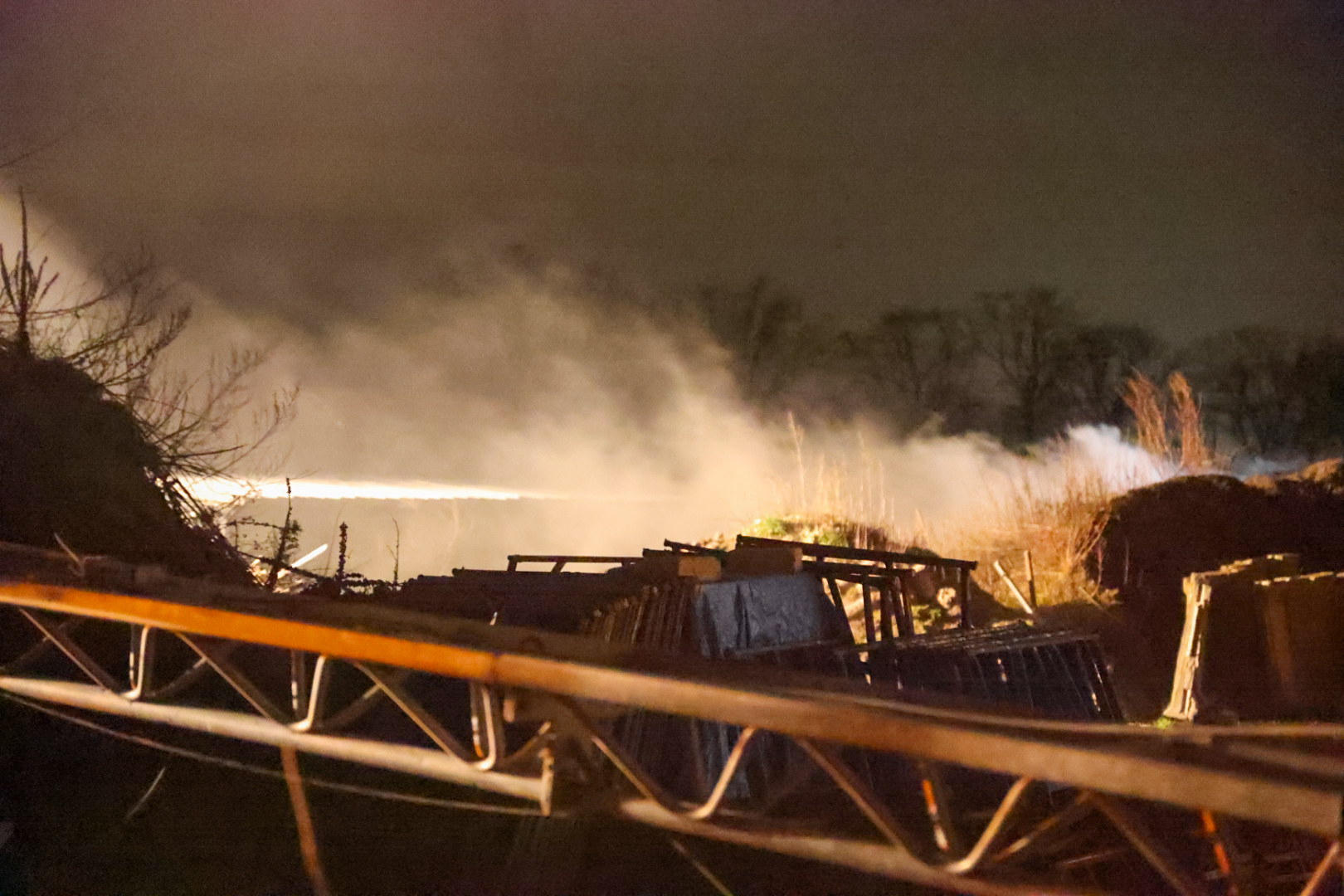 Brandweer blust brand in snoeiafval bij loods