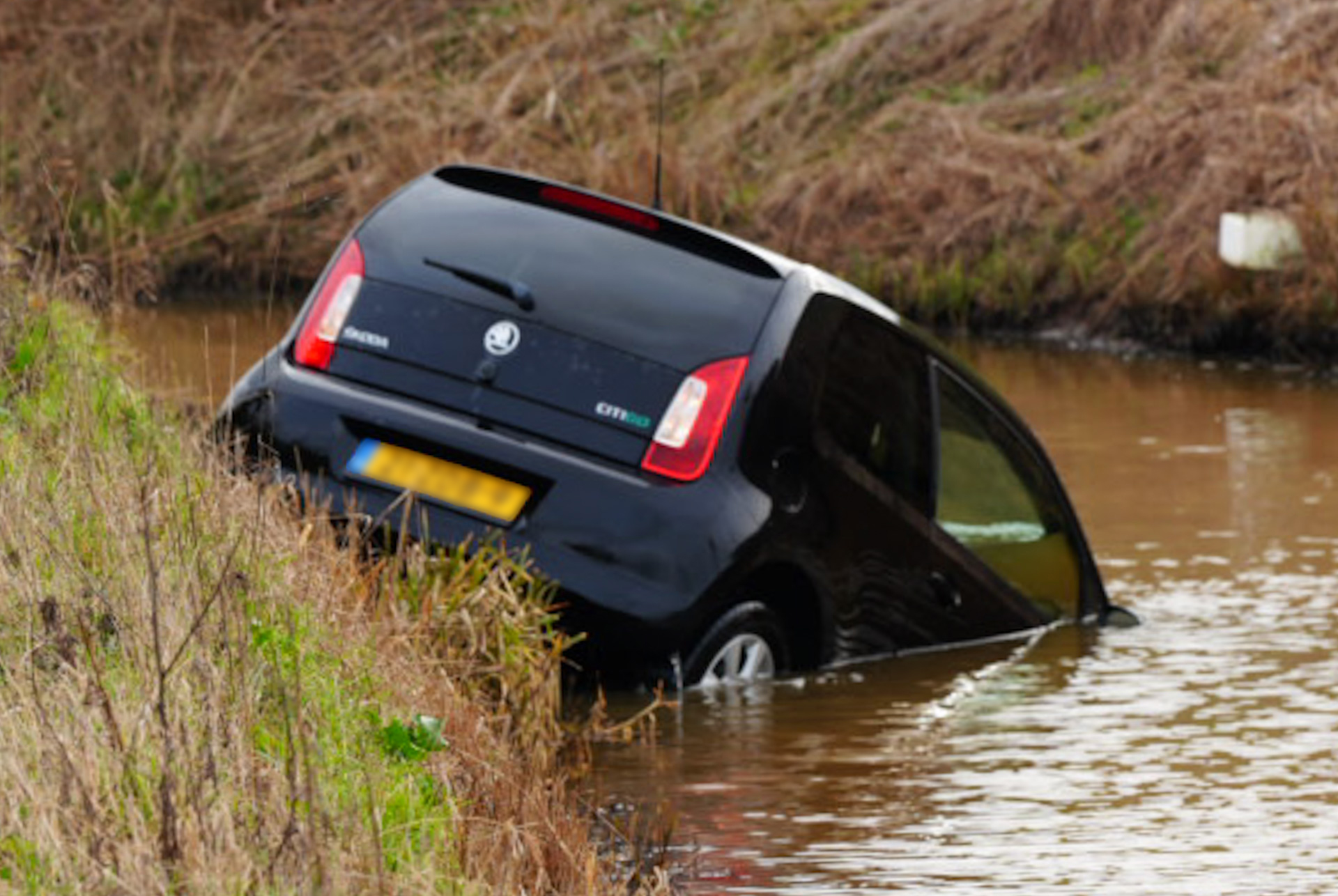 Auto rijdt sloot in met moeder en kind