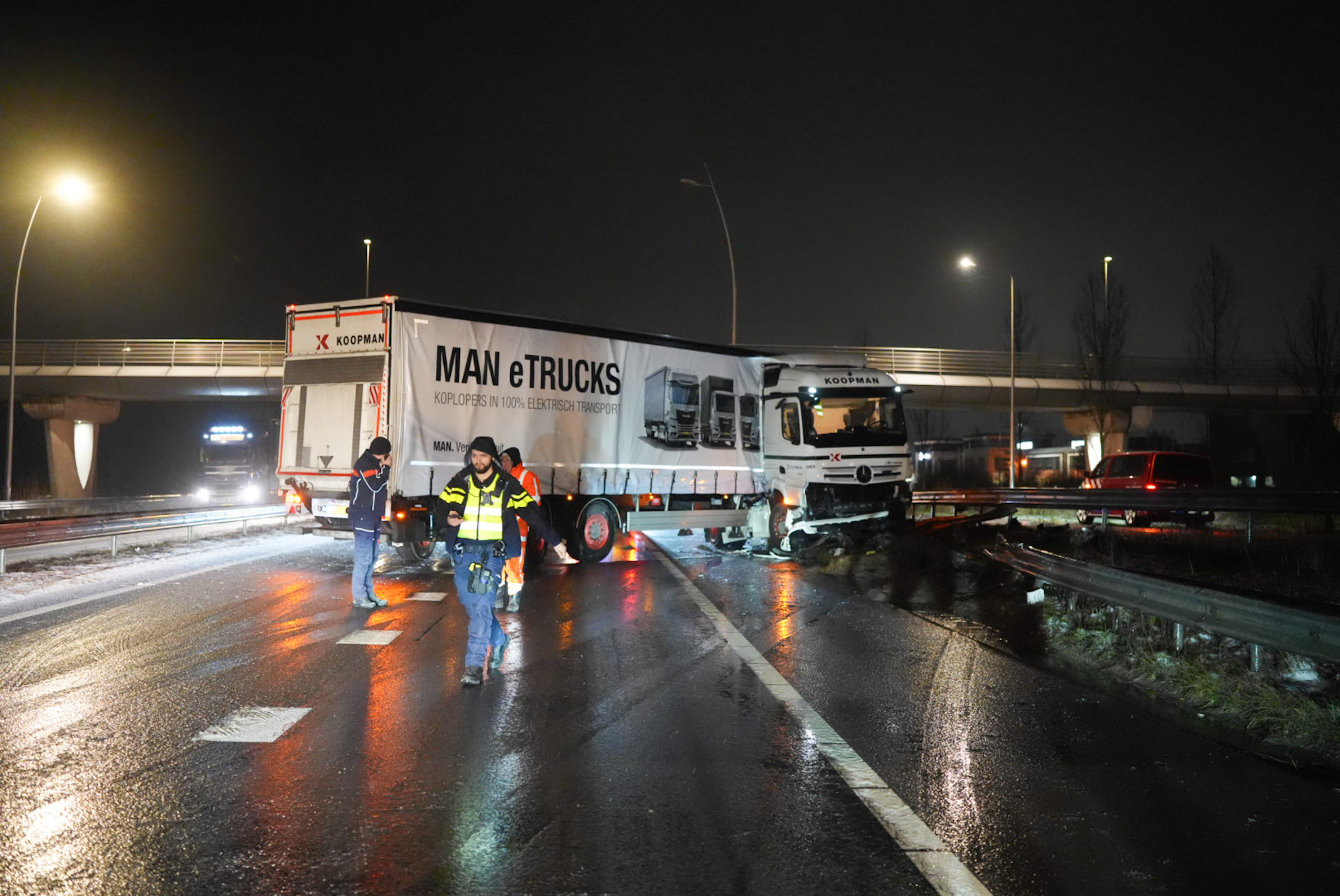 Vrachtwagen schaart op gladde weg en botst tegen vangrail