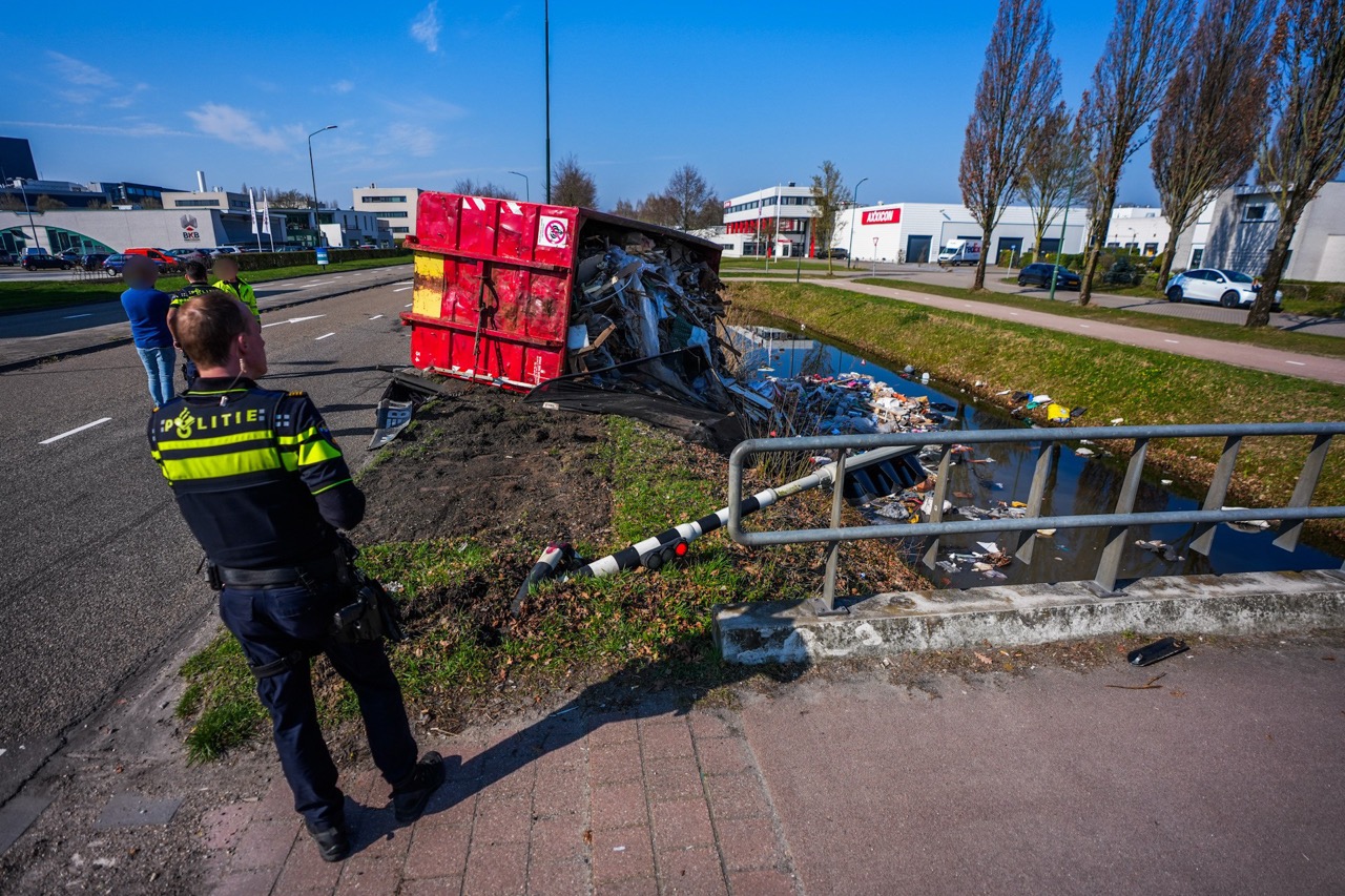 Container met puin valt van trailer